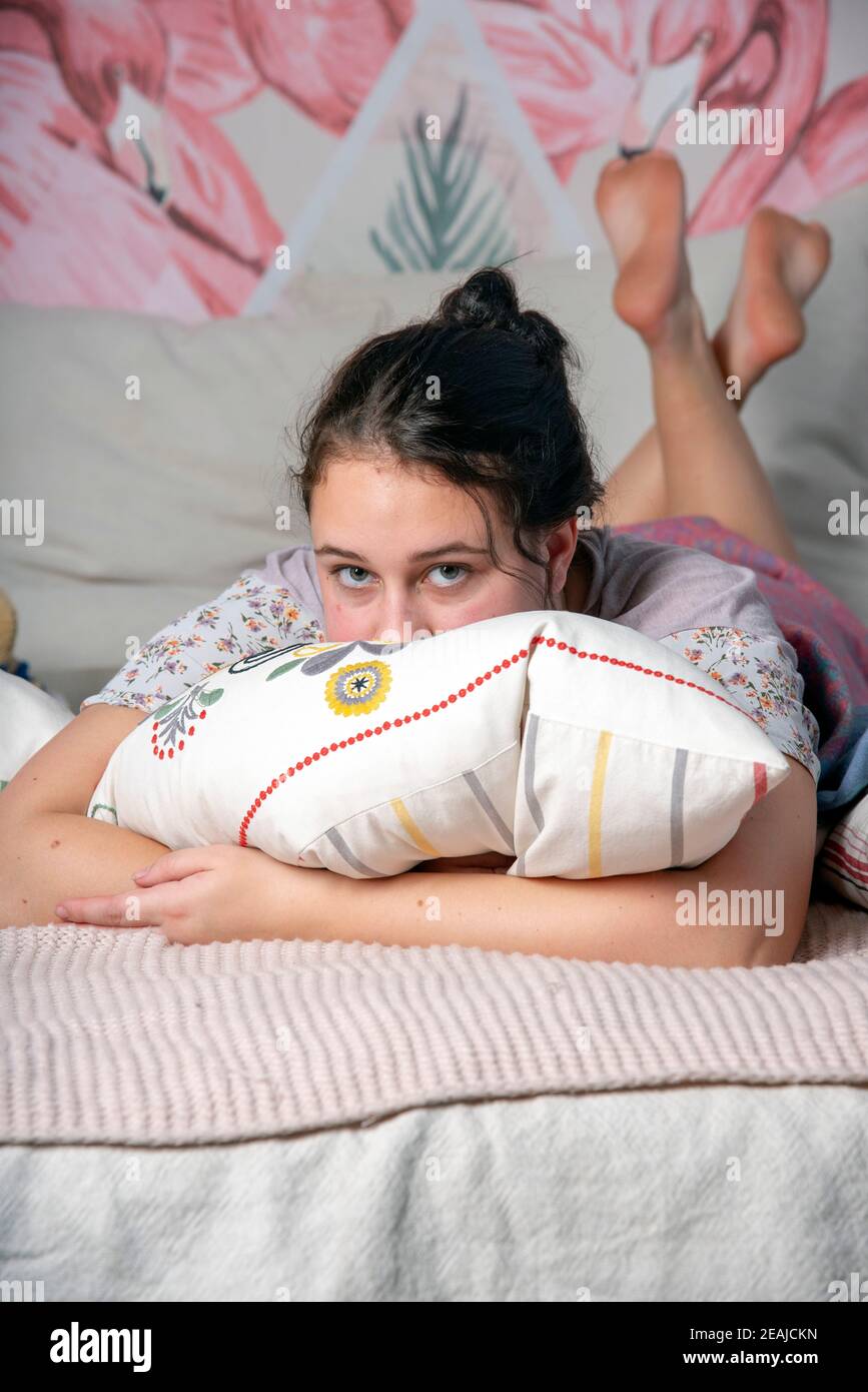 A teenage girl in pajamas is lying on the bed Stock Photo Alamy