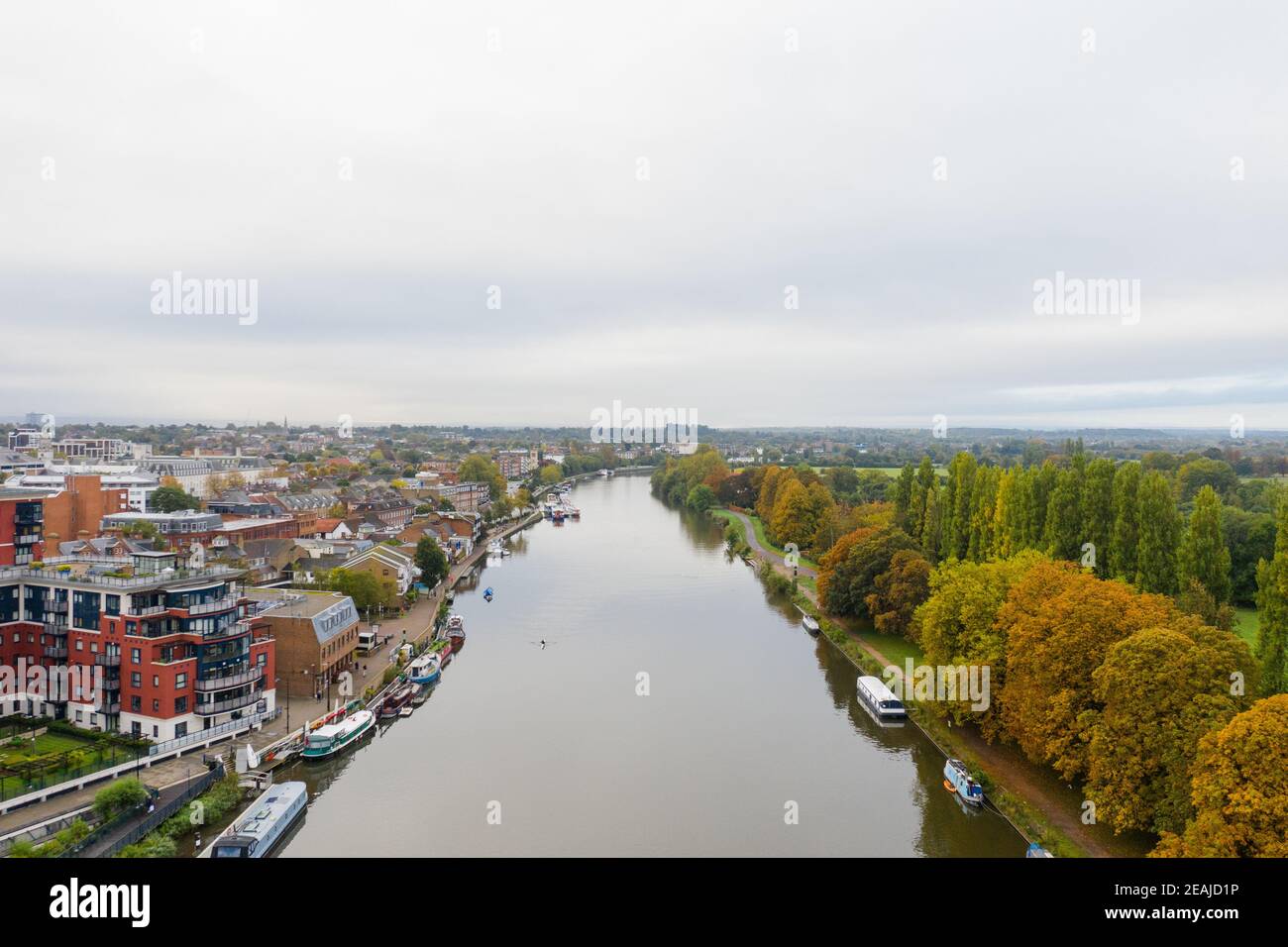 Aerial Landscape View Over a River in the Middle of a Town and a Forest Stock Photo