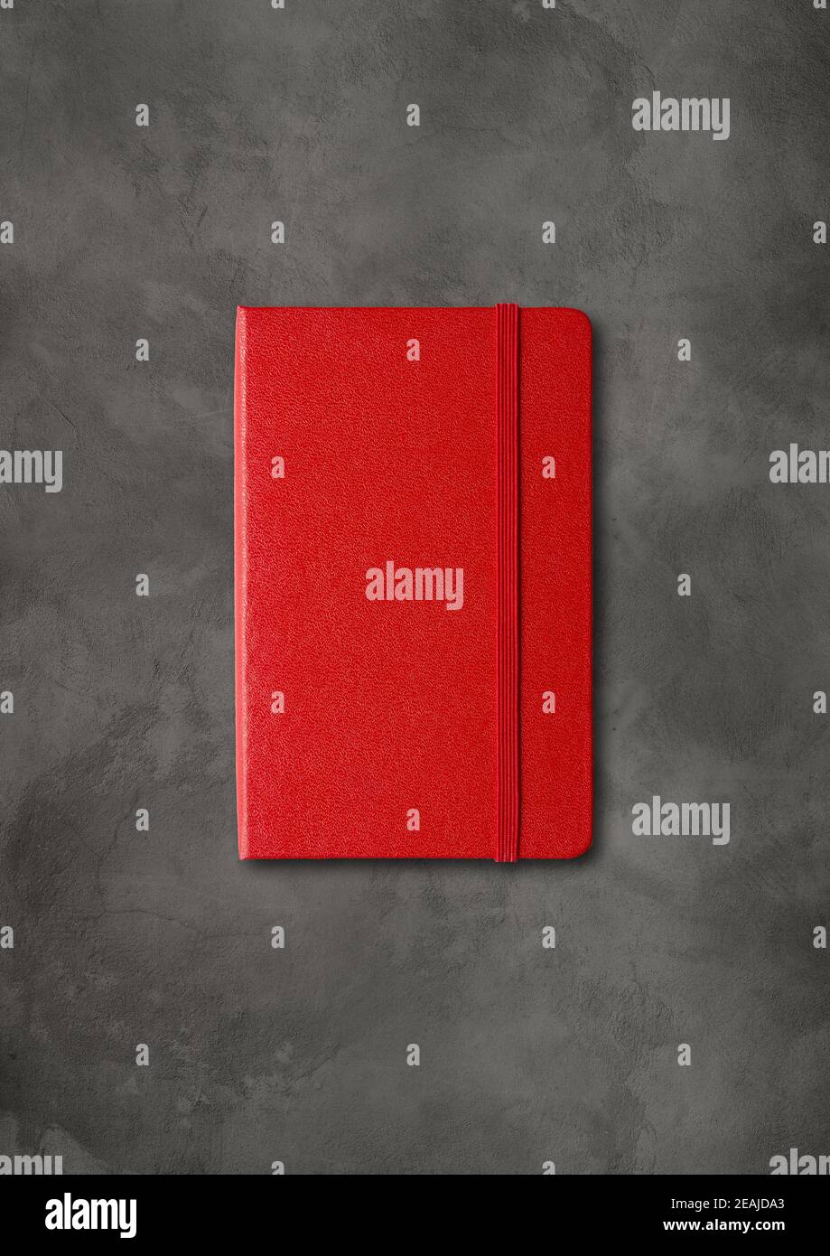 Red closed notebook on dark concrete background Stock Photo