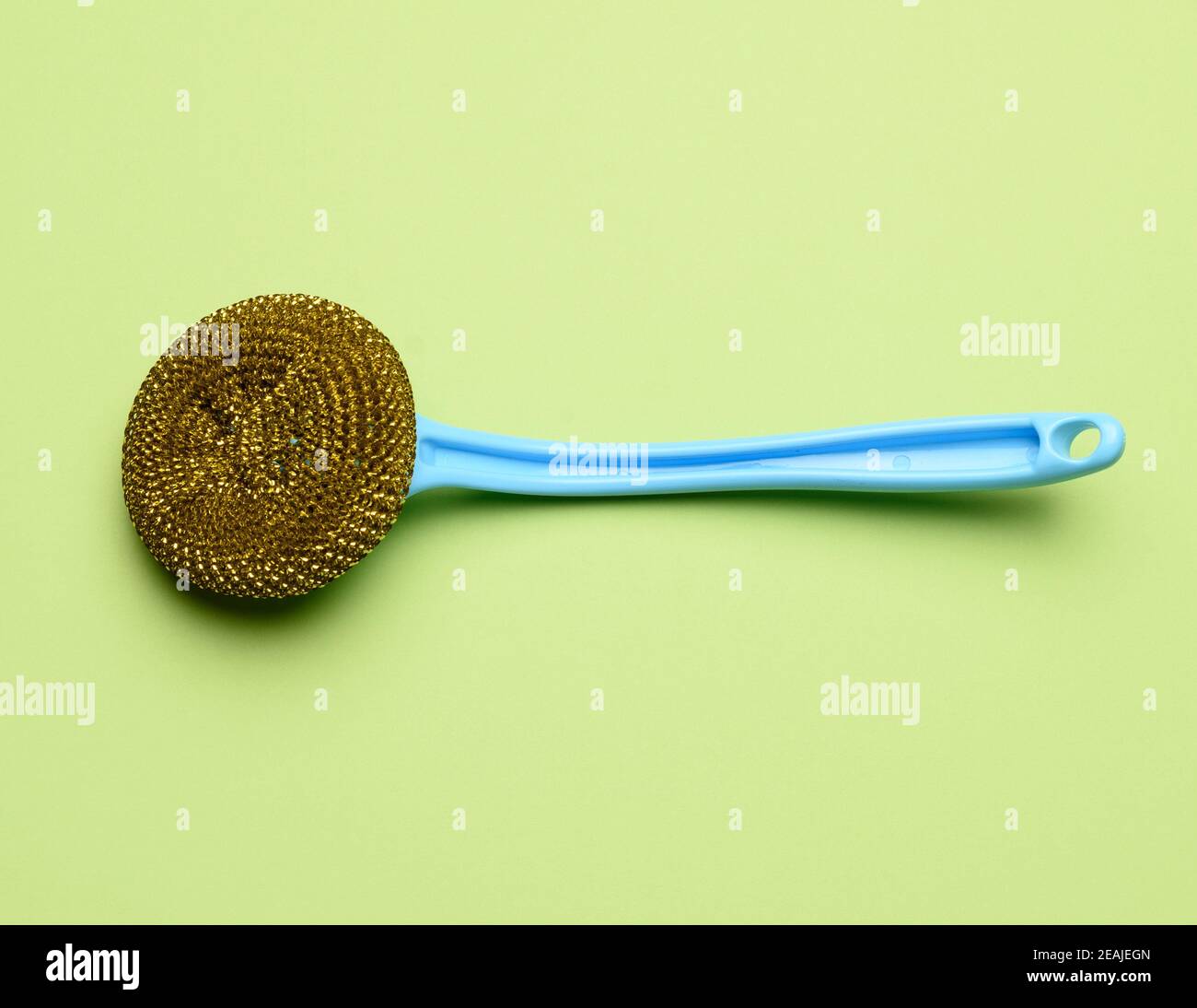 blue plastic brush for cleaning the house on a green background Stock Photo