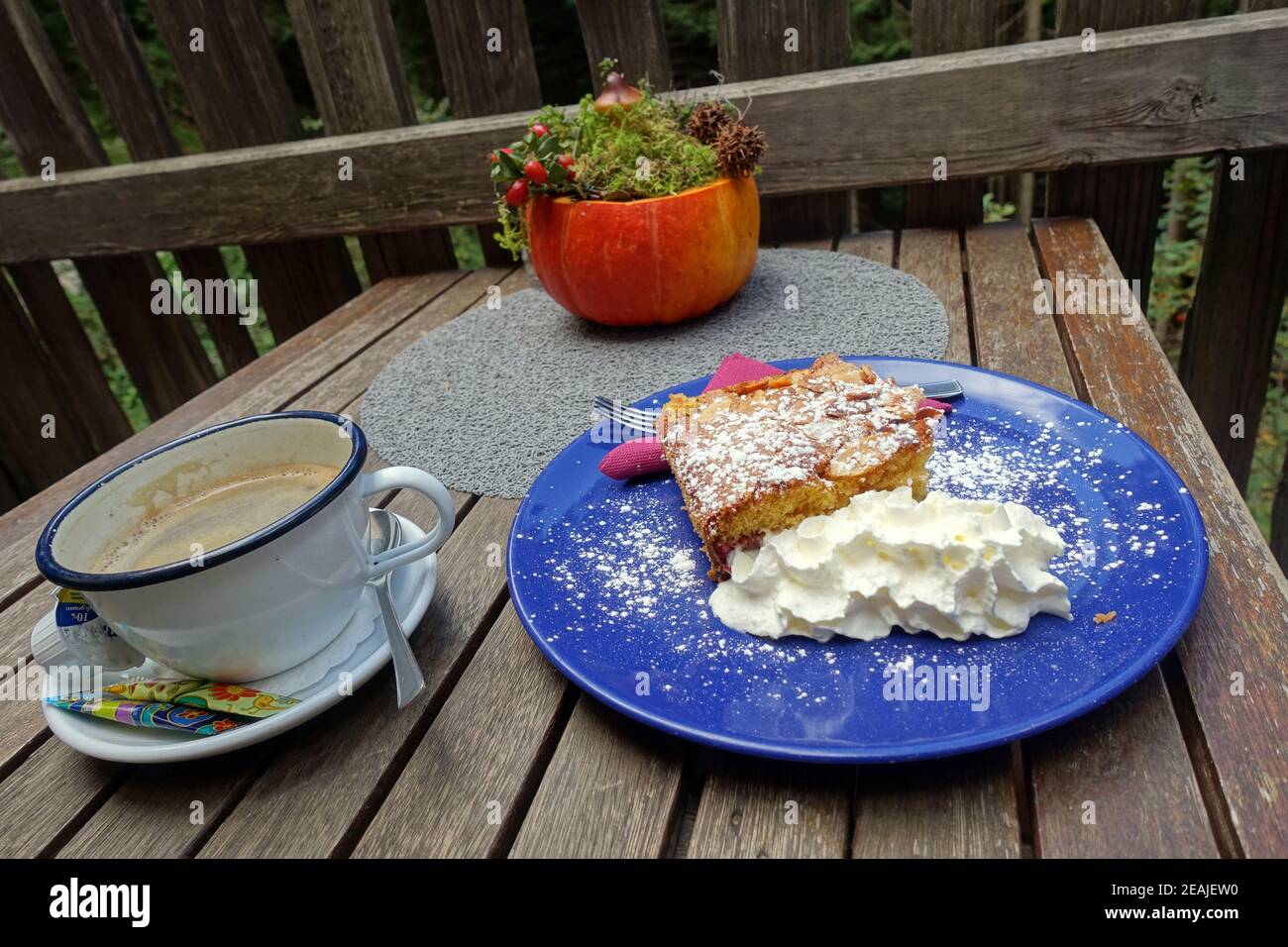 Pflaumenkuchen mit Sahne auf einem blauen Teller Stock Photo