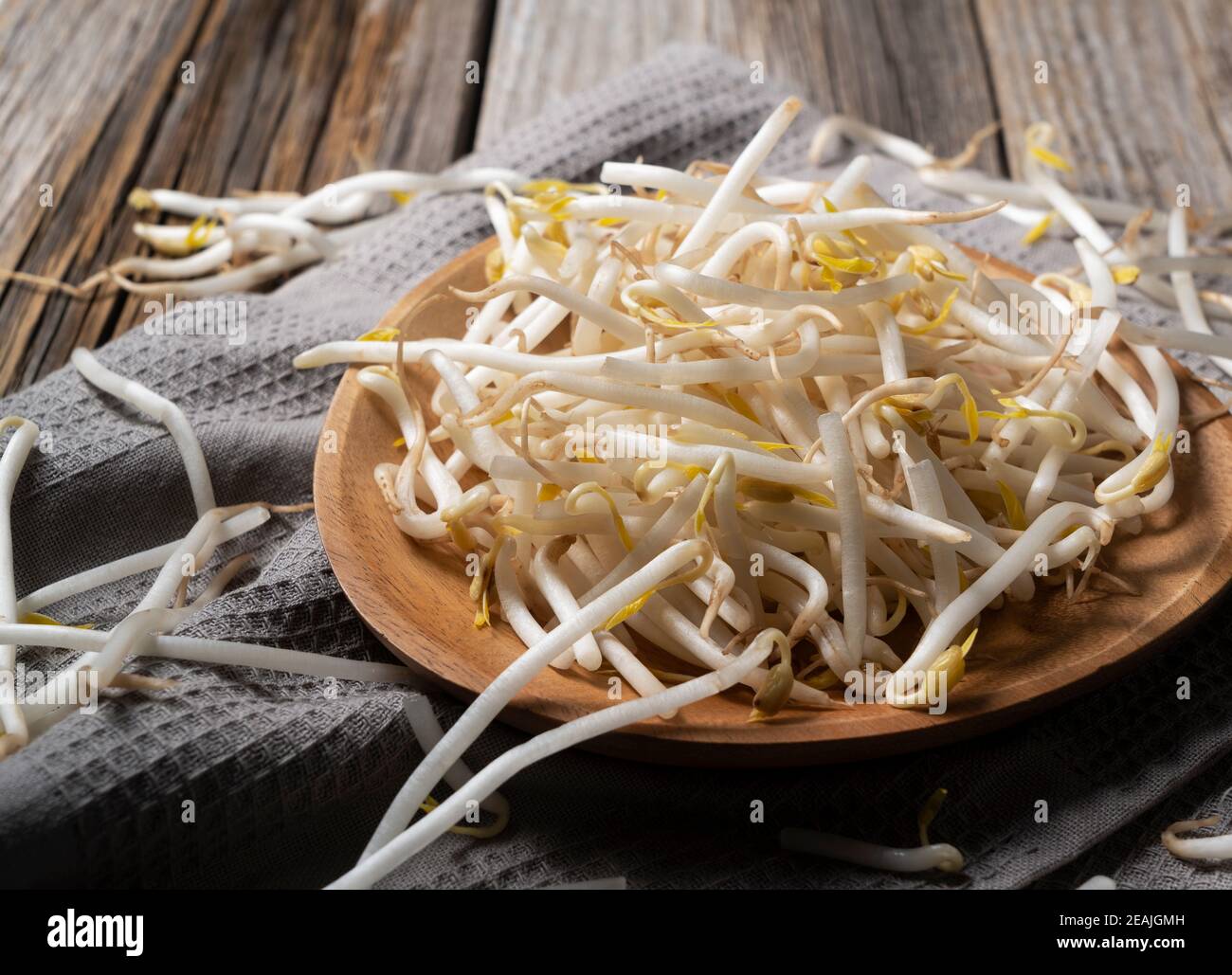 Bean sprouts in a wooden plate set against an old wooden background Stock Photo