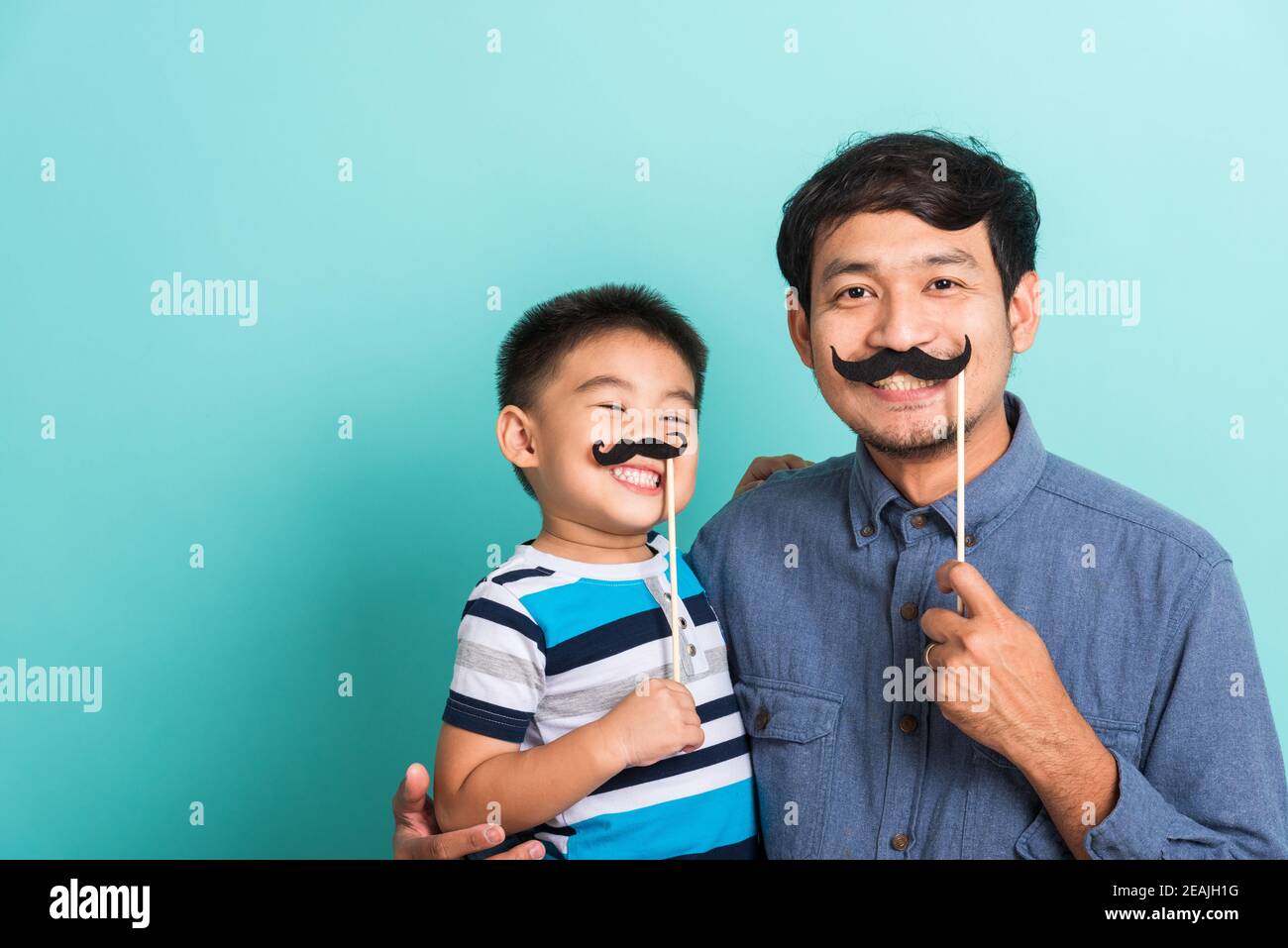 Family funny happy hipster father and his son kid holding black mustache props Stock Photo