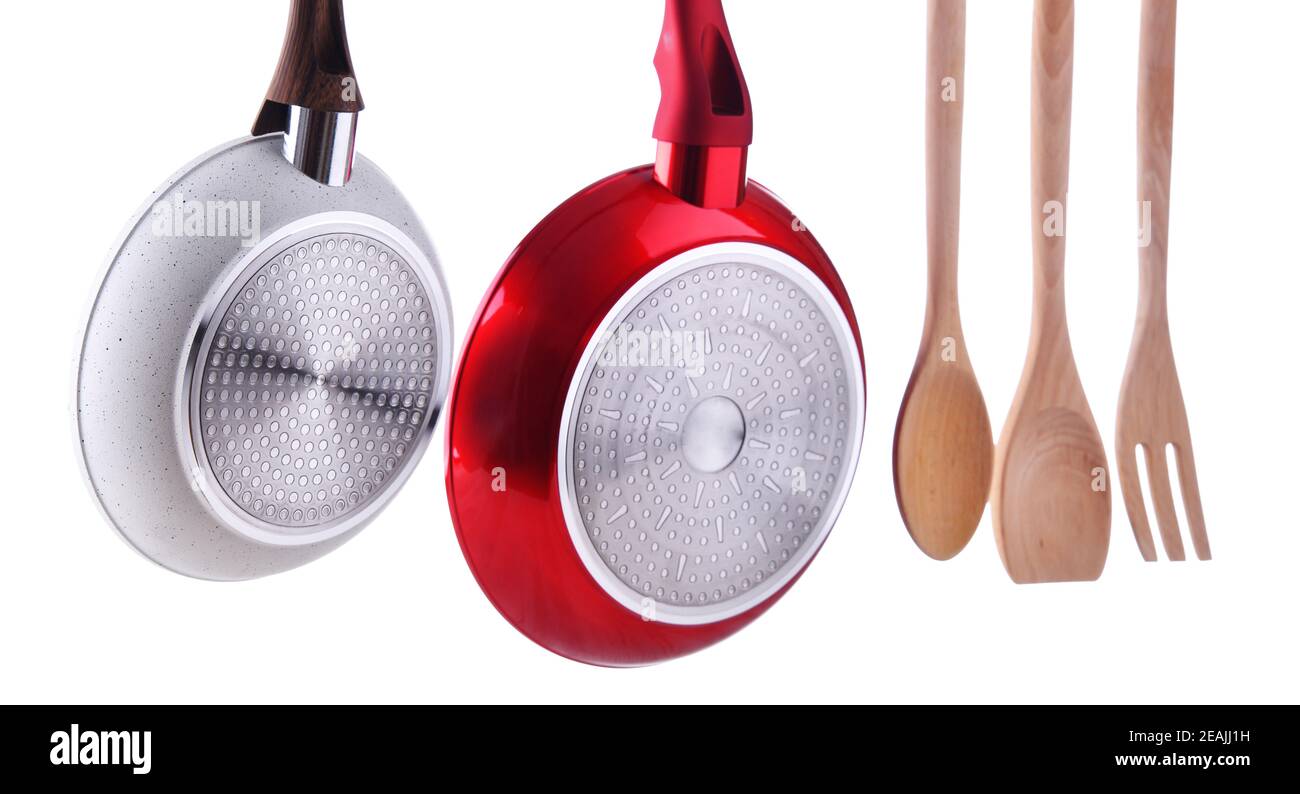Two hanging frying pans and kitchen utensils Stock Photo