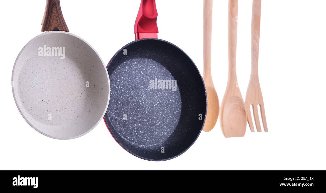 Two hanging frying pans and kitchen utensils Stock Photo