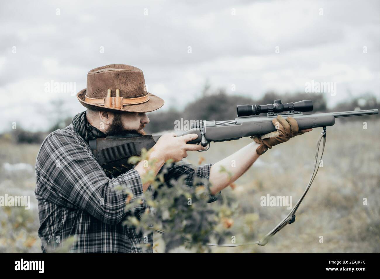Man shoots a rifle. Bearded man with scout rifle Stock Photo - Alamy