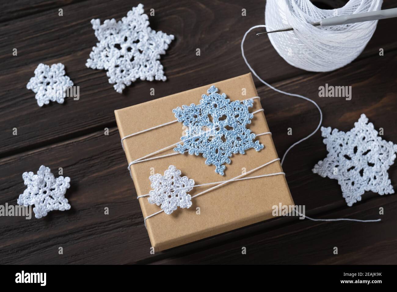 Idea gifts wrapping of the Christmas gift and decoration with knitted snowflakes. Stock Photo