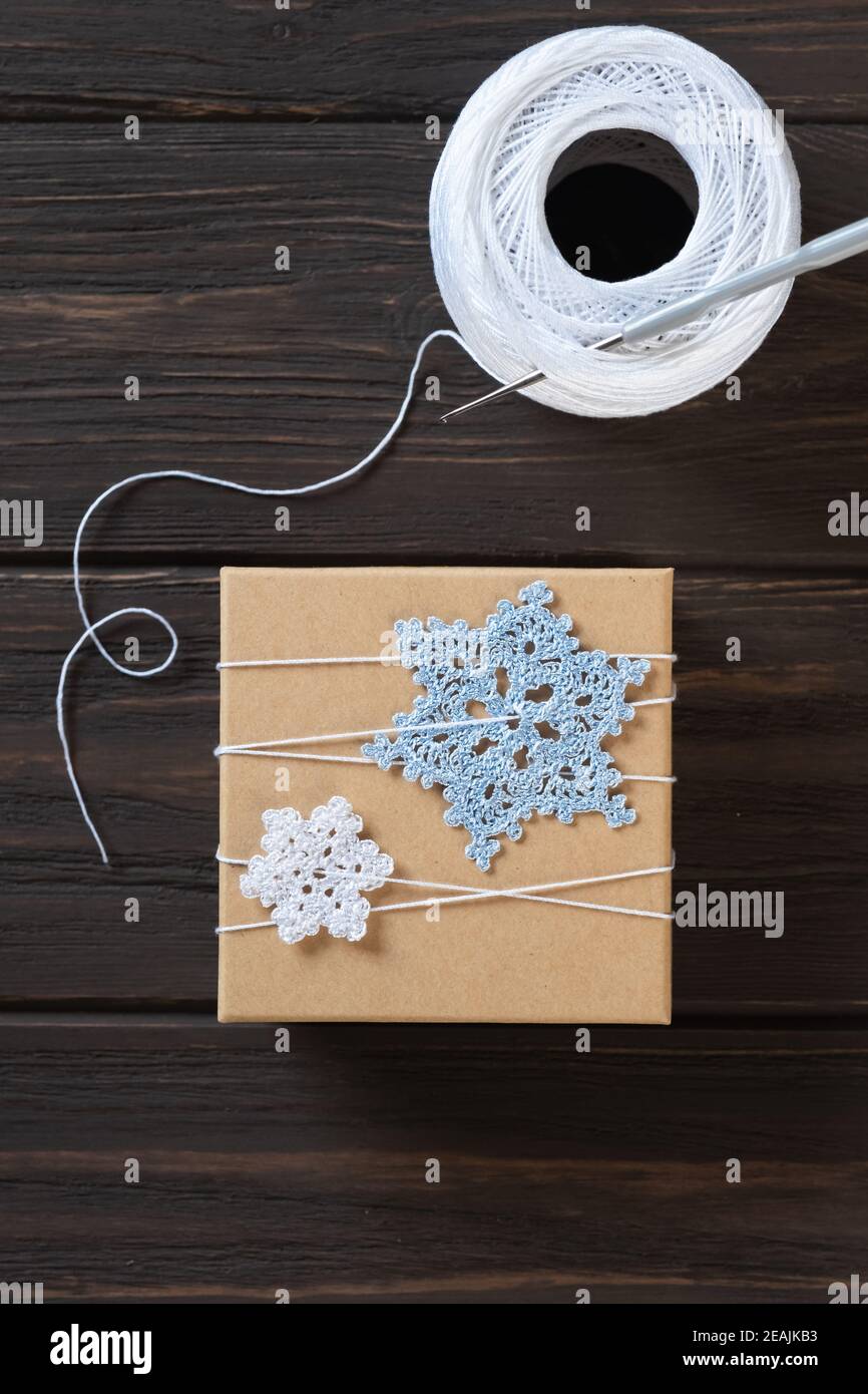 Idea gifts wrapping of the Christmas gift and decoration with knitted snowflakes. Stock Photo