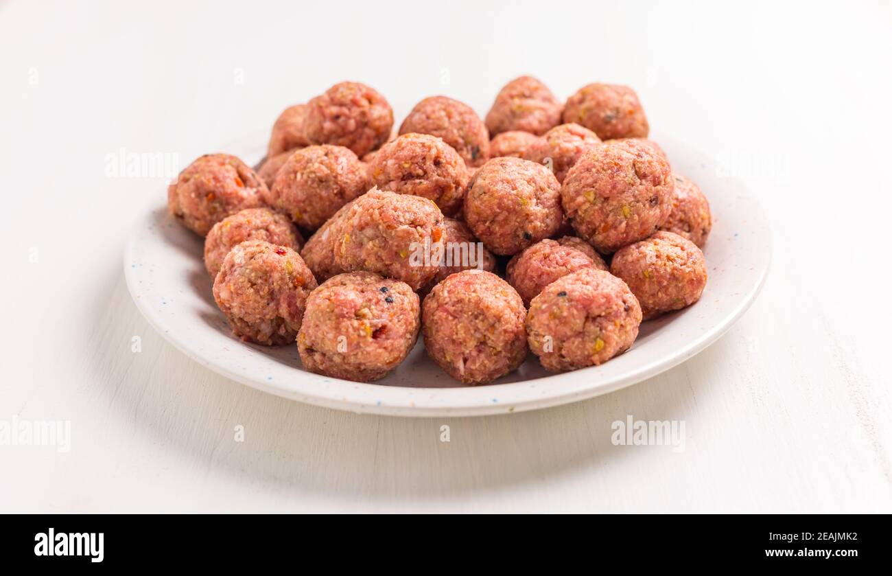 Raw meatballs on plate and white background Stock Photo