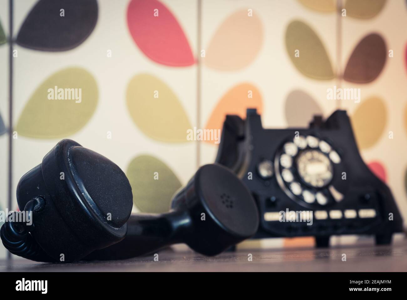 Old retro and vintage rotary phone off the hook, colorful wallpaper, selective focus Stock Photo
