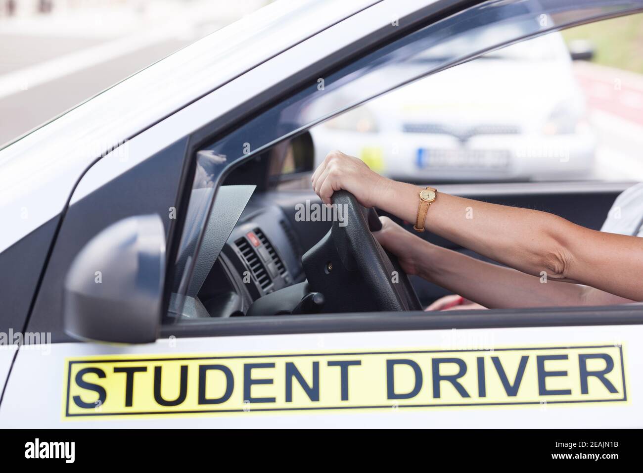 Learner driver holding steering wheel during driving lesson Stock Photo