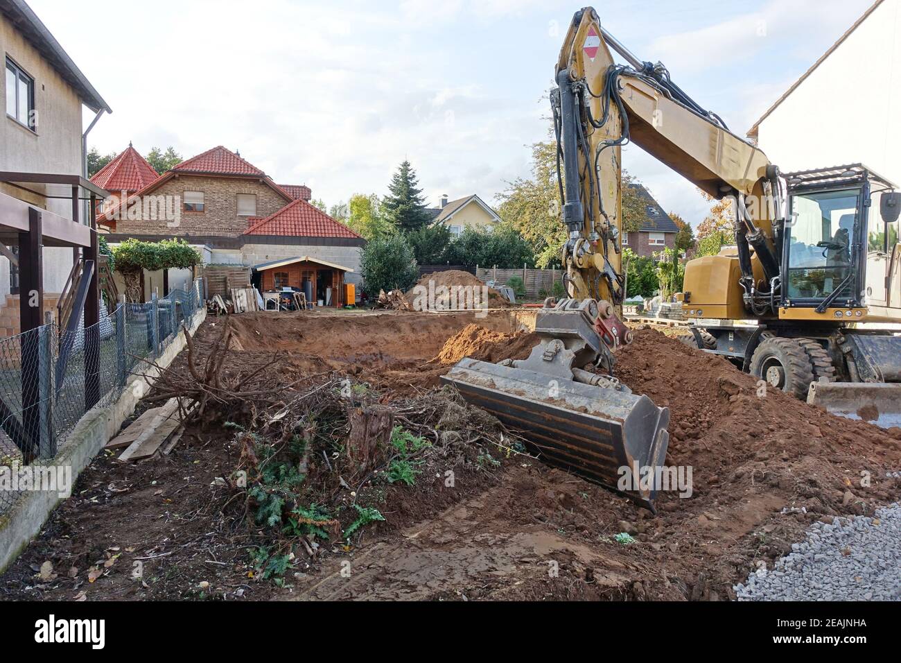 Bagger vor einer Baugrube zum Bau eines Wohnhauses Stock Photo