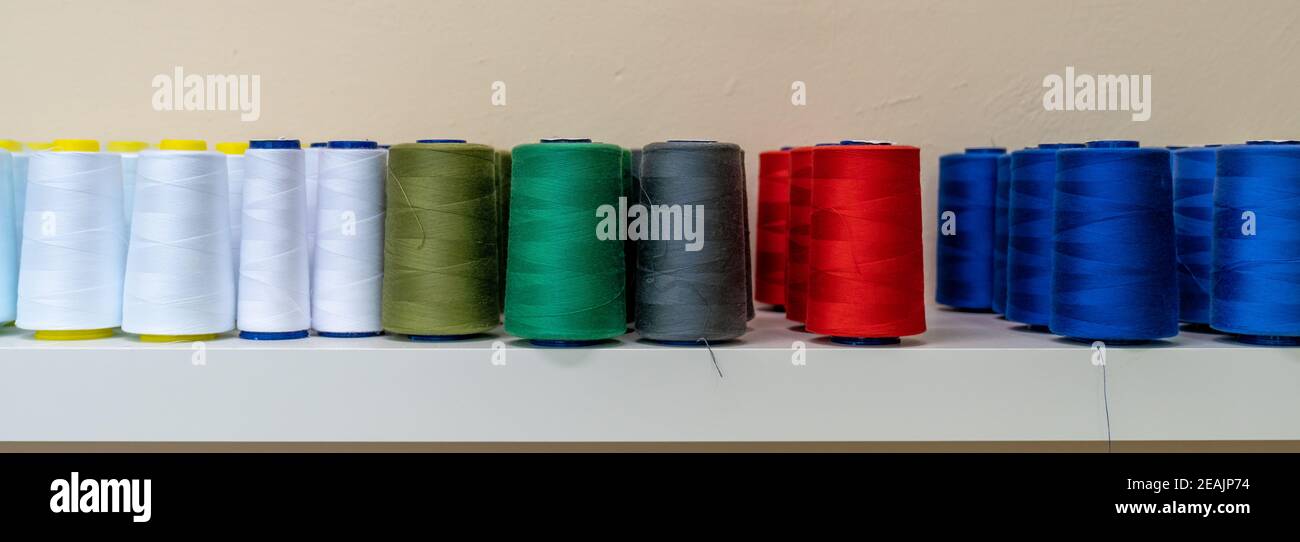 colored threads for the sewing machine on the shelf, banner Stock Photo ...
