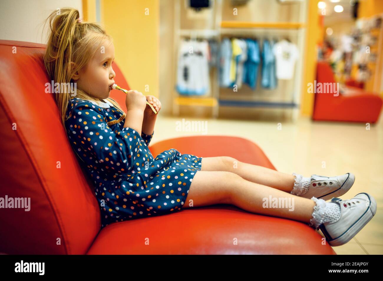 Little girl sitting on sofa in children's shop Stock Photo Alamy