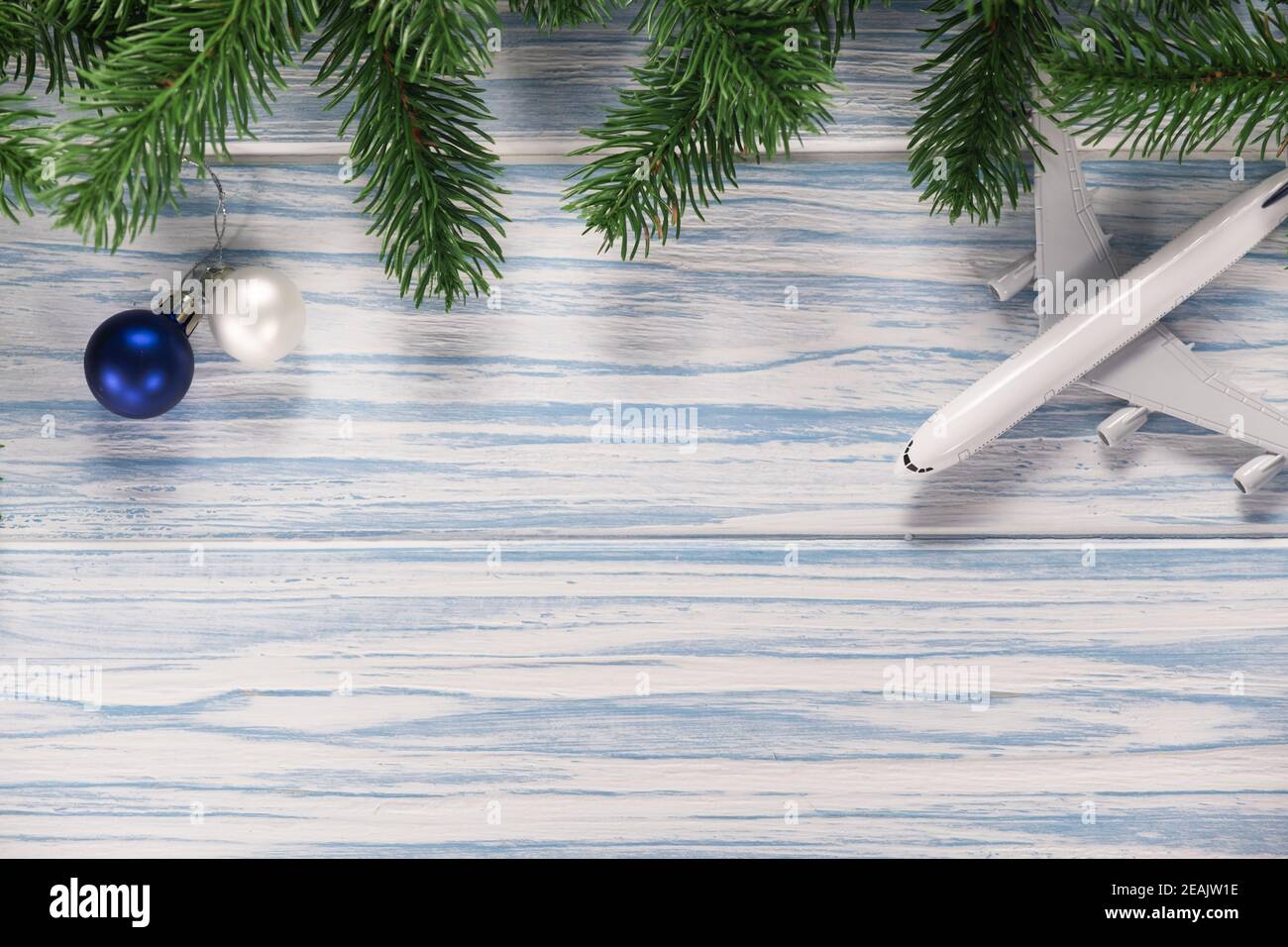 Christmas or New Year background with fir branches and plane model. Holiday travel concept. Stock Photo