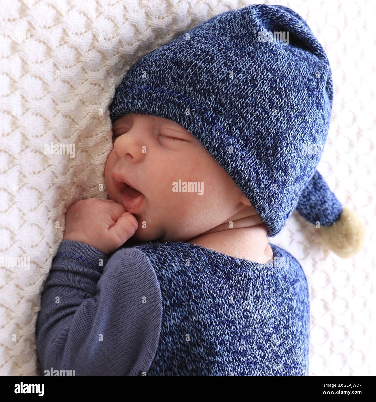 A newborn wearing a hat sleeping with an open mouth Stock Photo Alamy