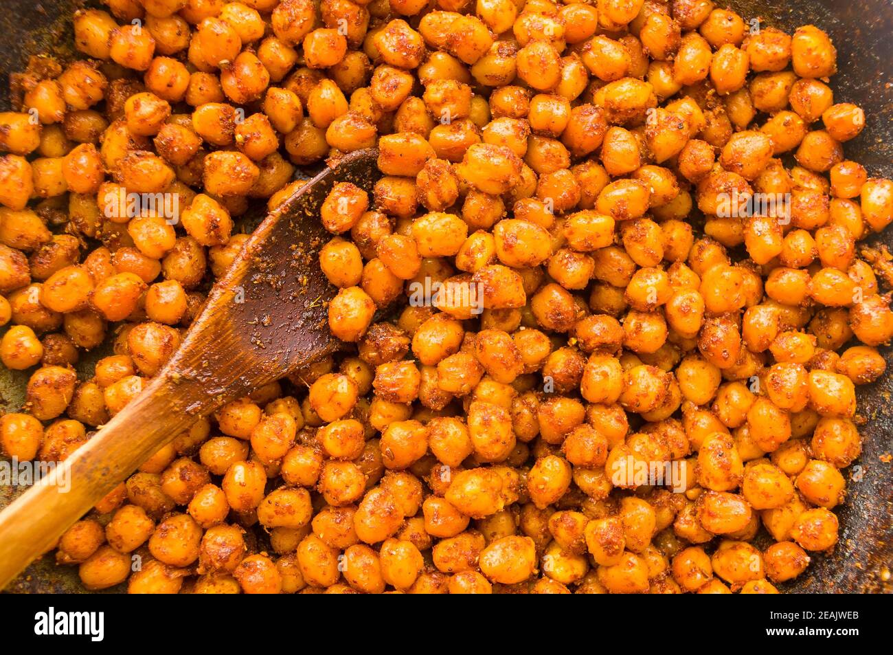 Cooking chickpeas with spices in a pan, close up Stock Photo
