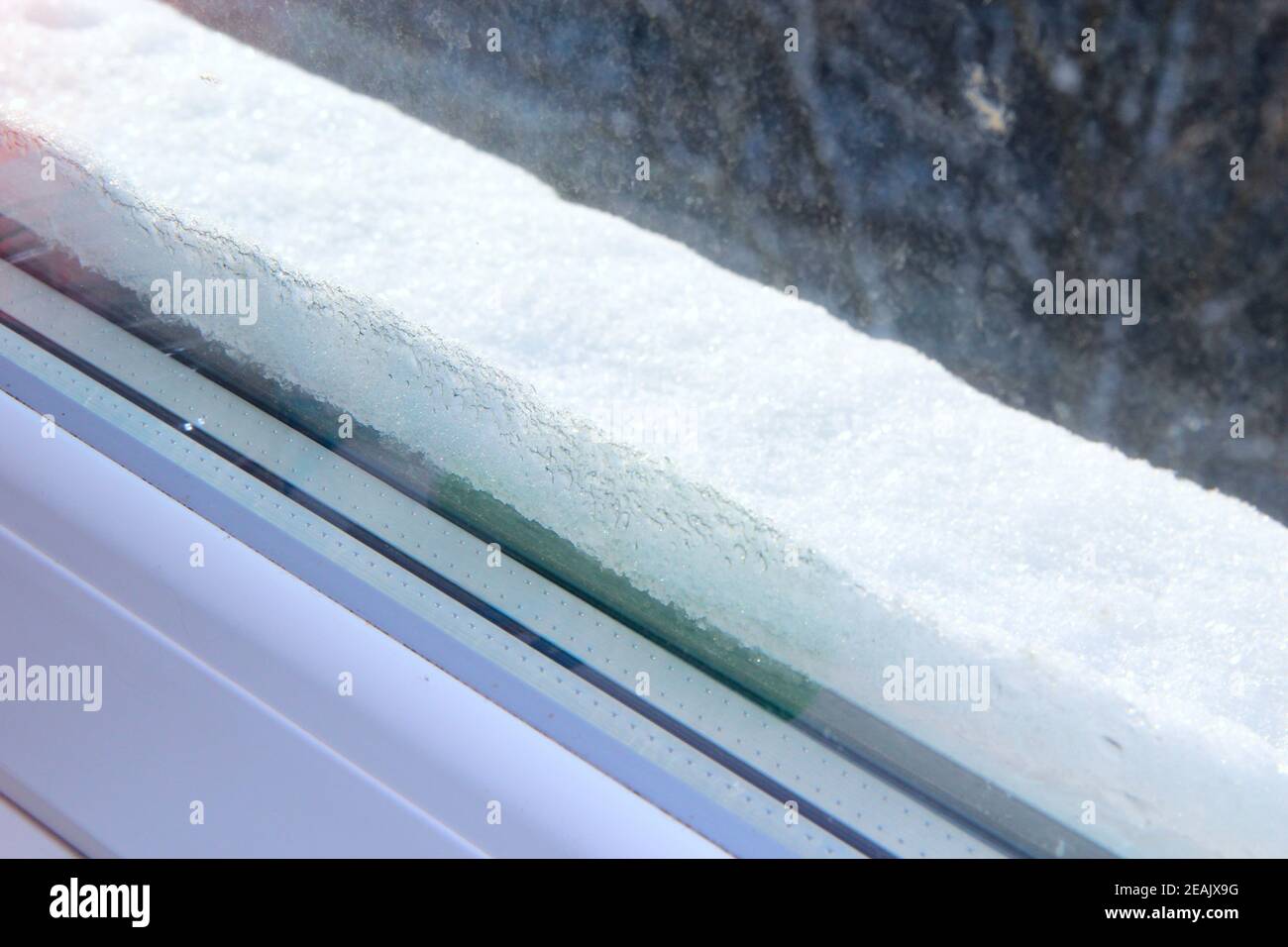 Bad weather outside. Thick layer of snow on window-sill beyond window Stock Photo