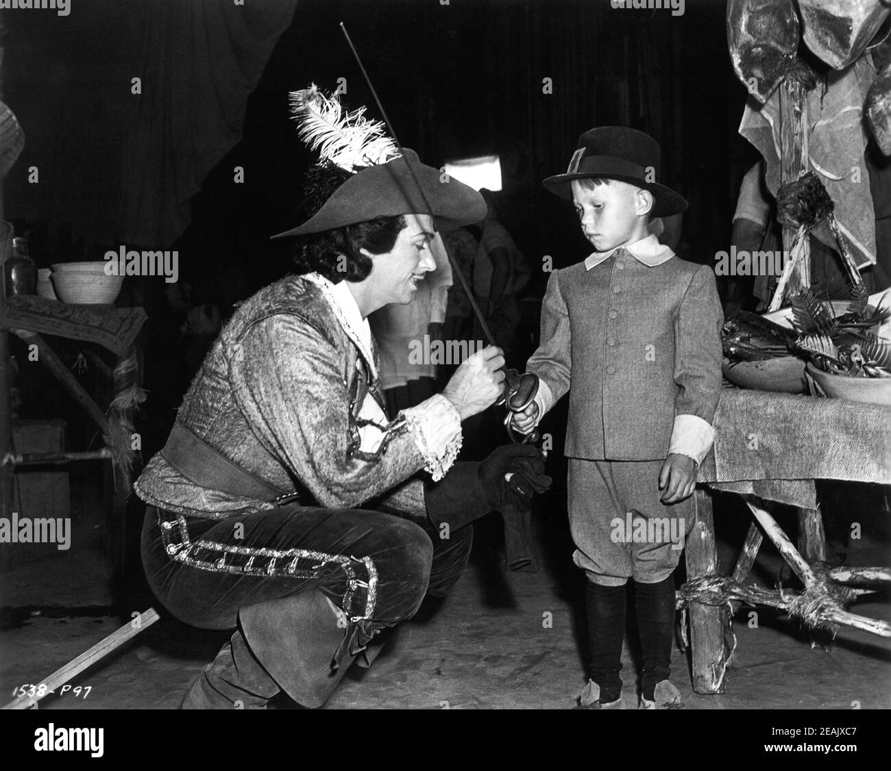 DOUGLAS FAIRBANKS Jr showing Sword to young boy in costume on set candid during making of THE EXILE 1947 director MAX OPHULS producer Douglas Fairbanks Jr Fairbanks Company / Universal - International Stock Photo