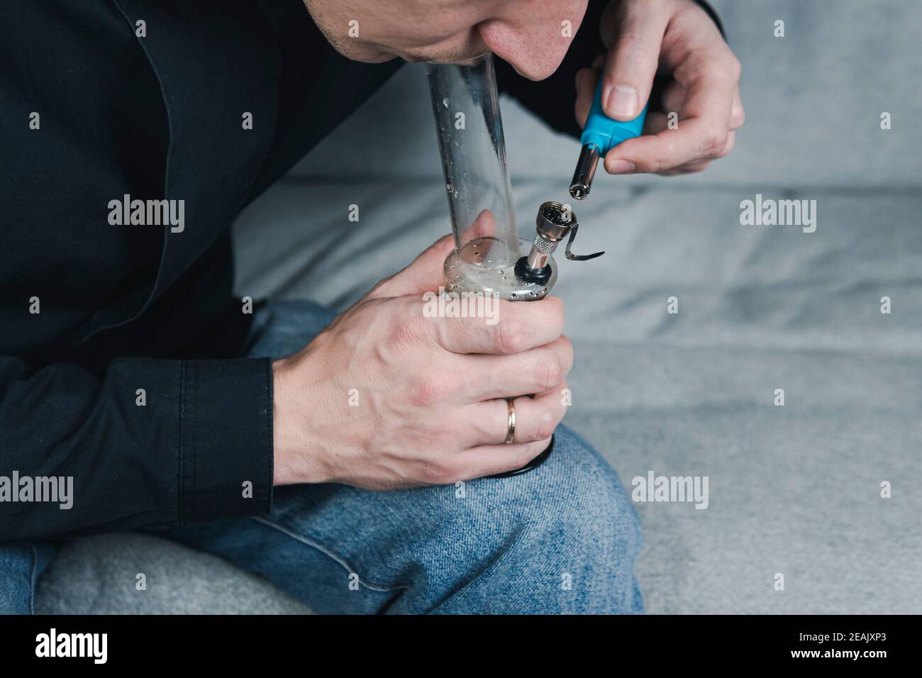 The young person smoking medical marijuana with bong, indoors Stock Photo