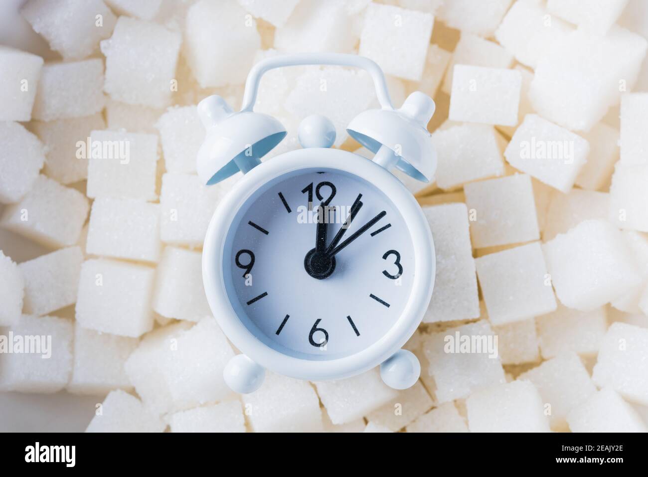 Sugar cube texture background sweet food ingredient and alarm clock Stock Photo