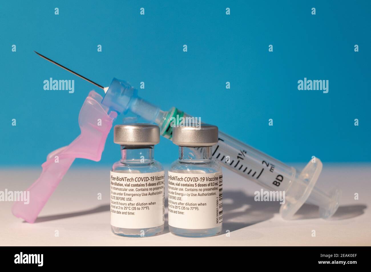 Two vials of Pfizer - BioNTech COVID-19 vaccine for coronavirus treatment and a syringe Stock Photo