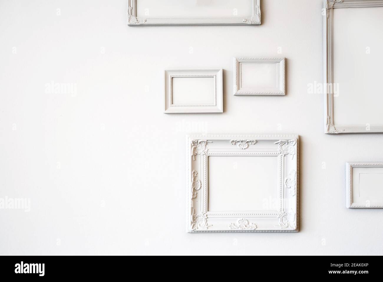 White various antique blank photo or picture frames on the white wall modern design, minimal interior design, copy space or space for text Stock Photo