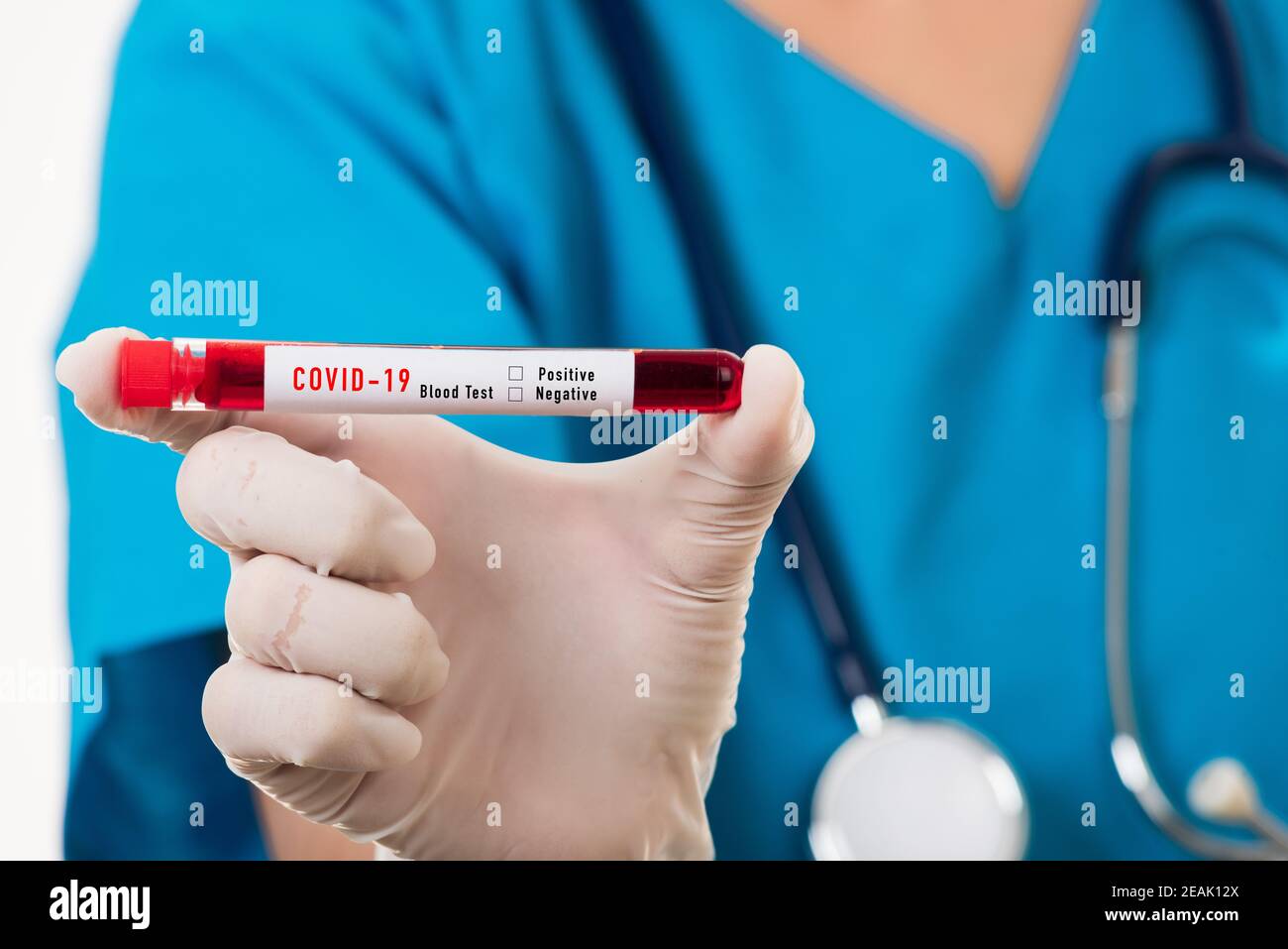 Nurse in blue uniform wear a mask holding test tube sample Coronavirus test blood Stock Photo