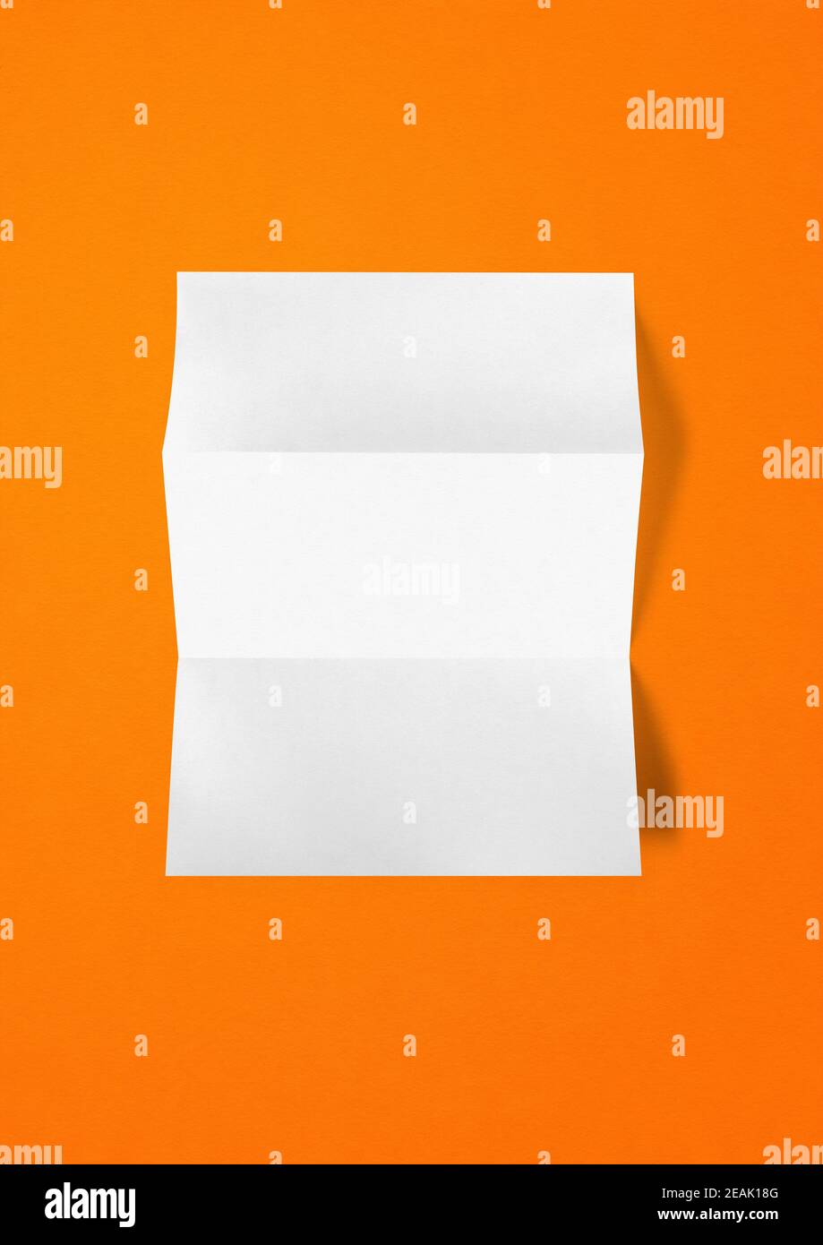 Blank folded White A4 paper sheet mockup template on orange background Stock Photo