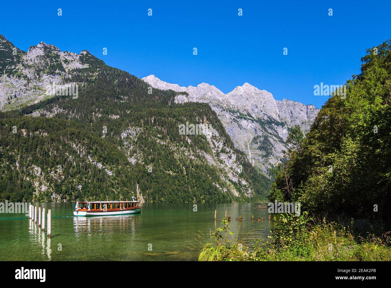 Lake Koenigssee with rocks and excursion boat in the Berchtesgaden Alps ...