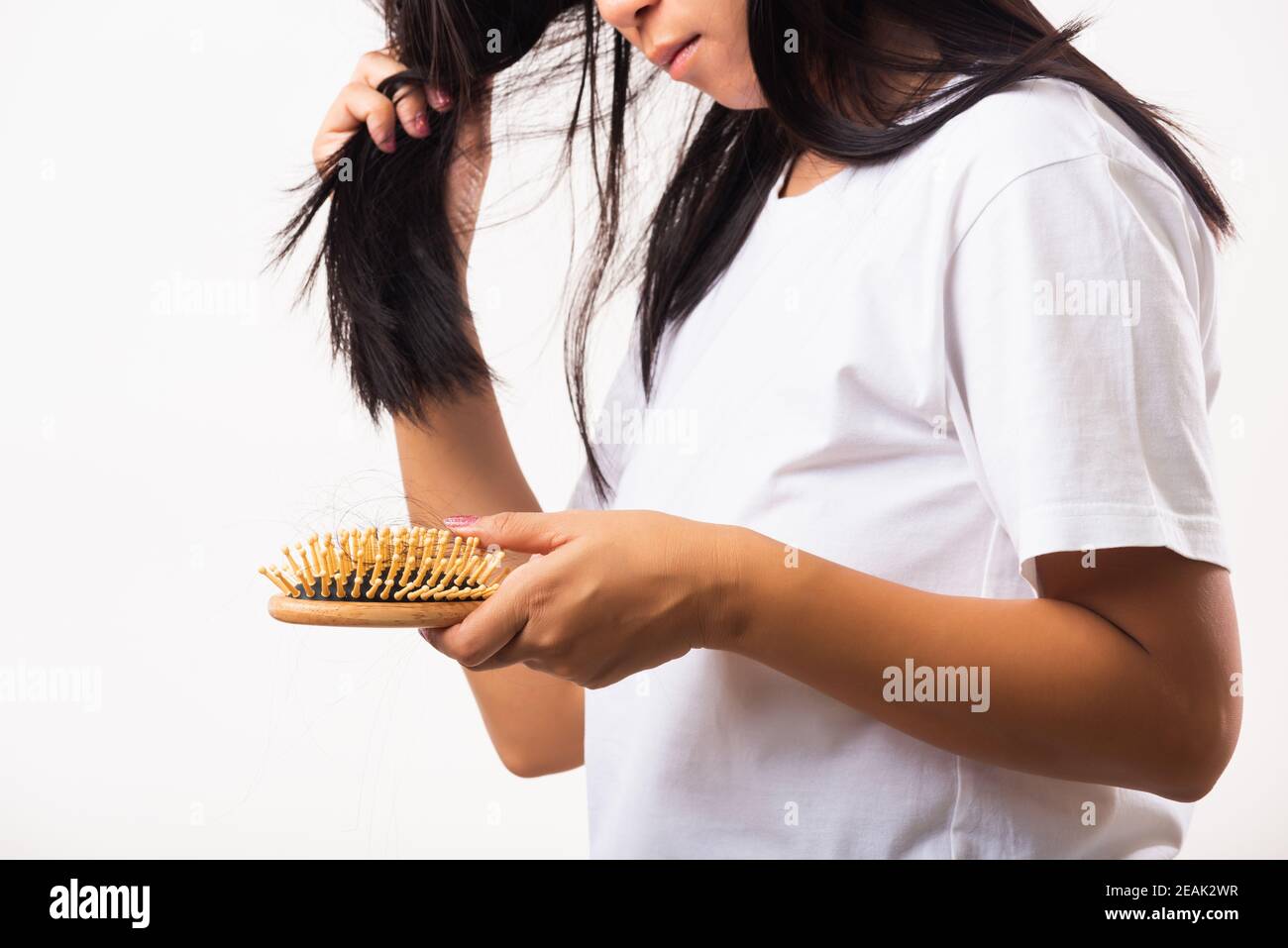 Woman weak hair her hold hairbrush with damaged long loss hair in comb brush on hand Stock Photo