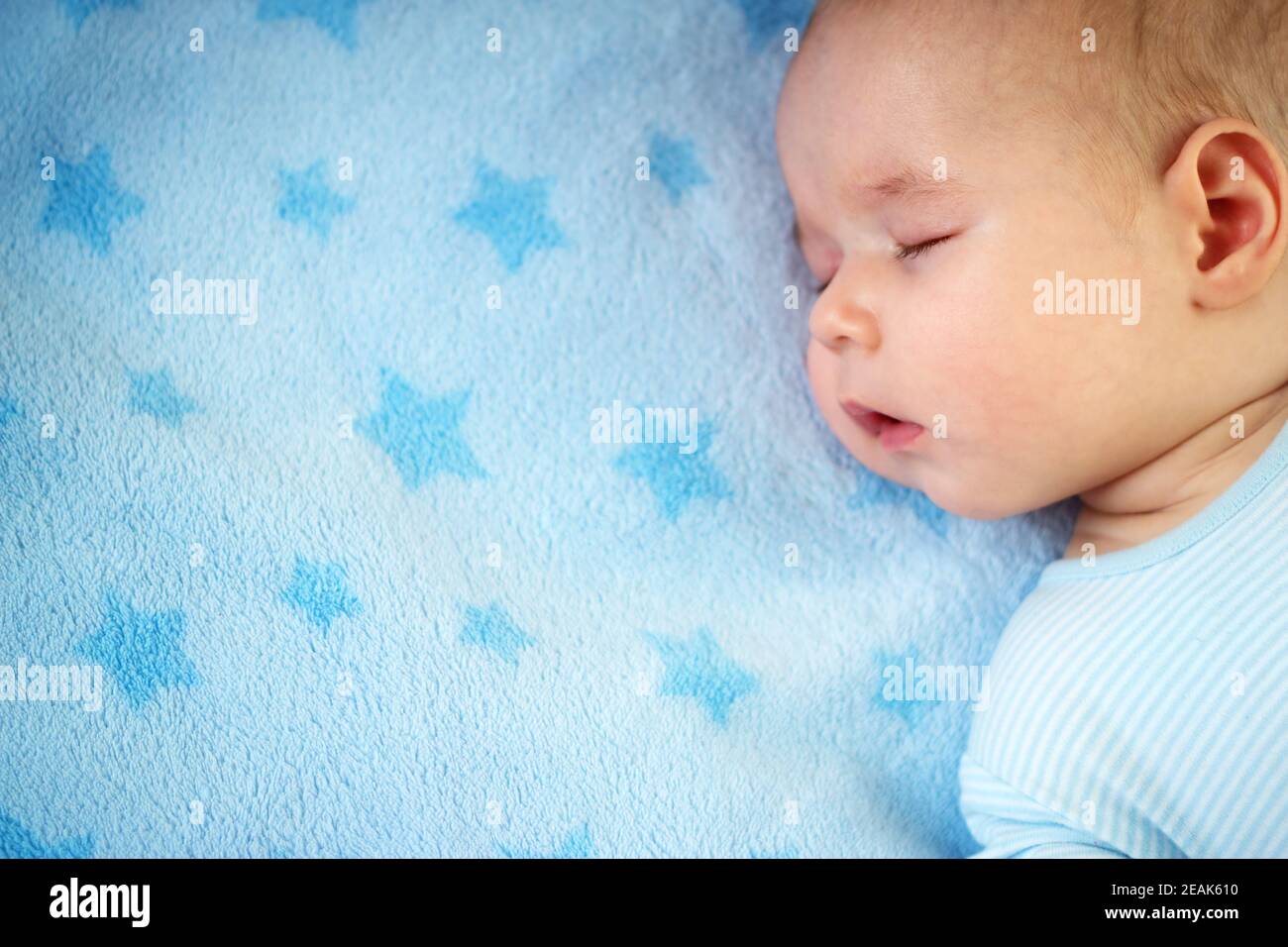 three month old baby sleeping on blue blanket Stock Photo Alamy