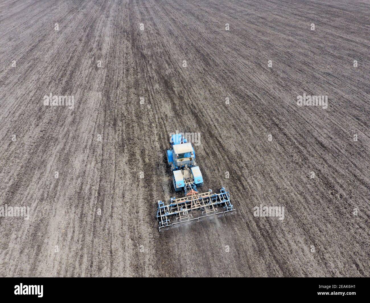 Young Farmer Sowing Crops At Field With Pneumatic Sowing Machine