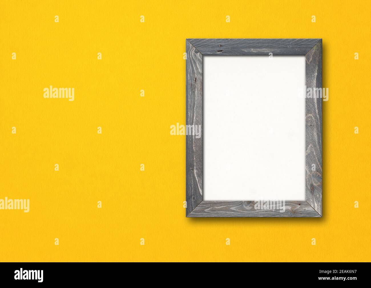 Old rustic wooden picture frame hanging on a yellow wall. Horizontal banner Stock Photo