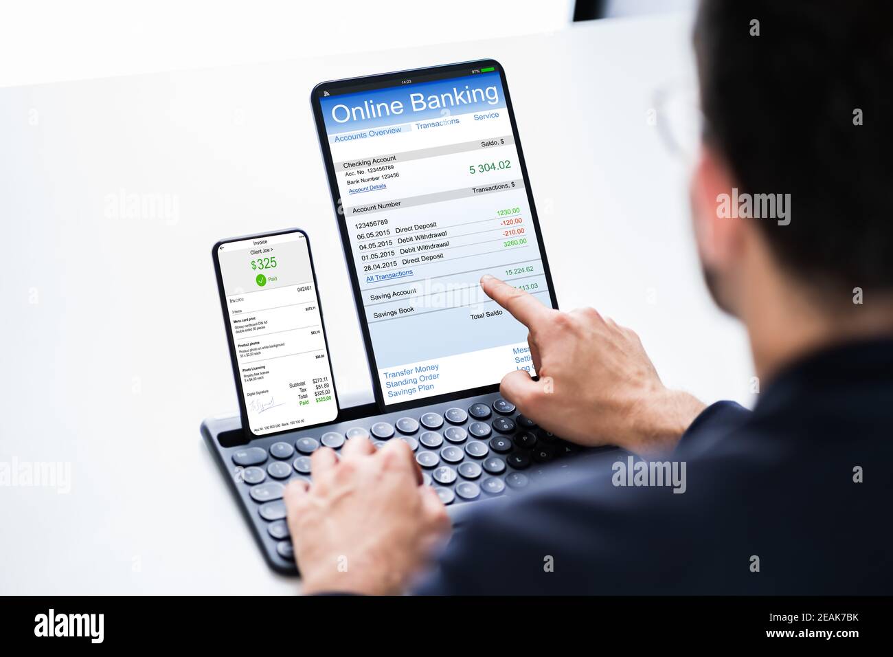 Young Businessman Looking At Invoice While Doing Online Banking Stock Photo