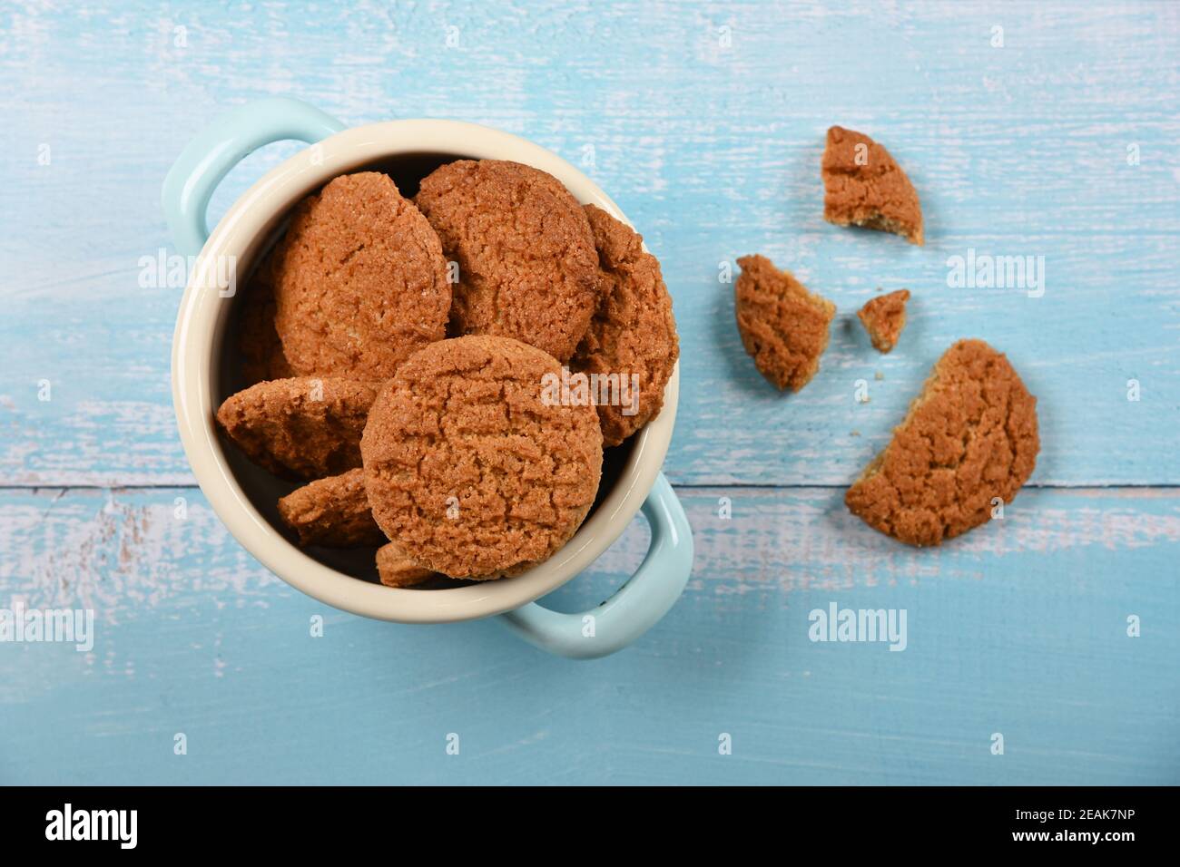 Oatmeal cookies in pannikin on blue table Stock Photo