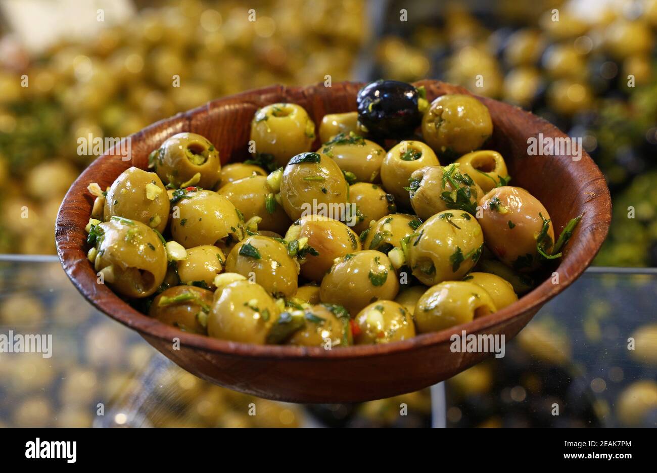 Green olives in wooden bowl on retail display Stock Photo
