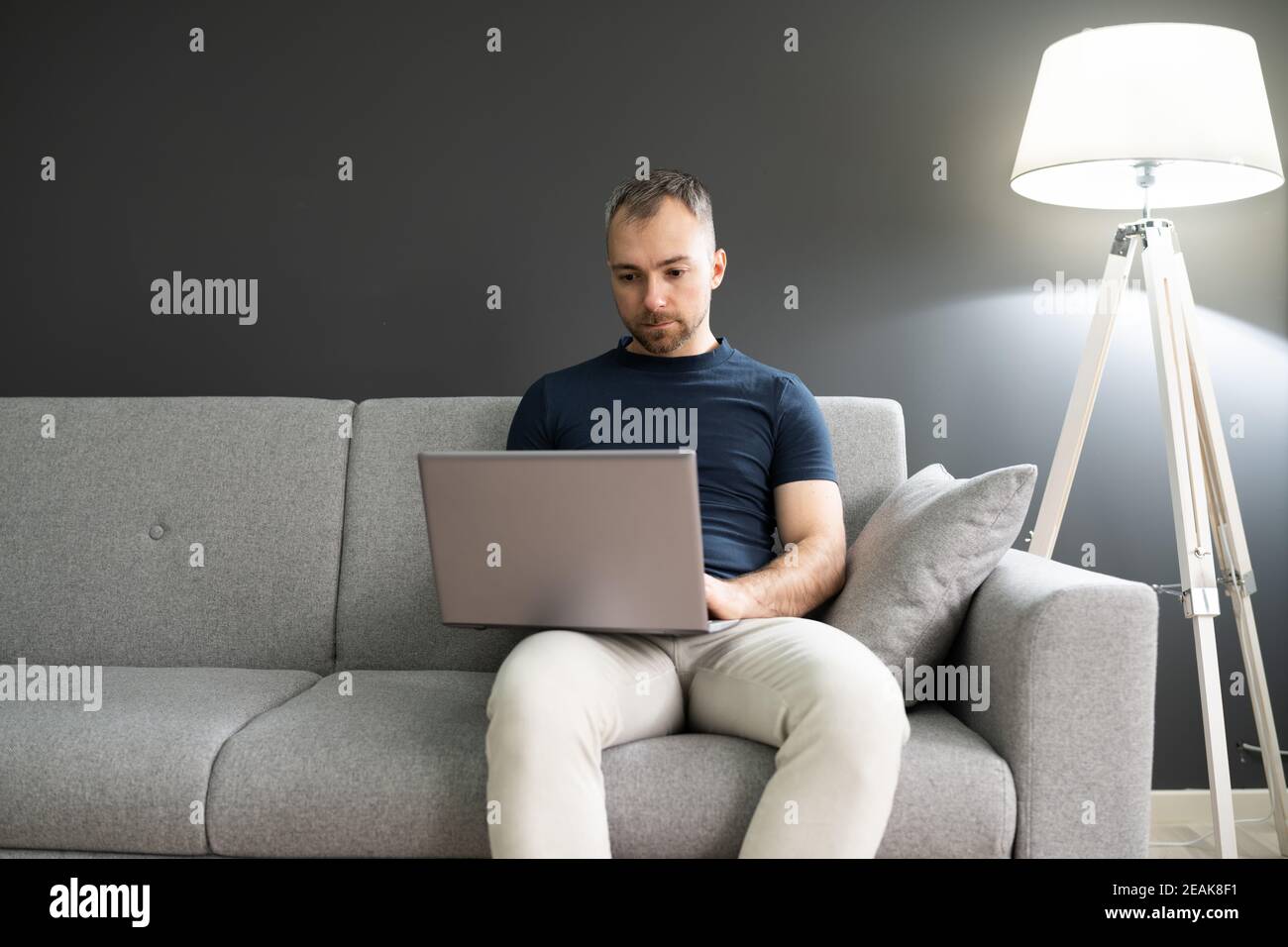 Man Sitting In Sofa And Using Laptop Stock Photo