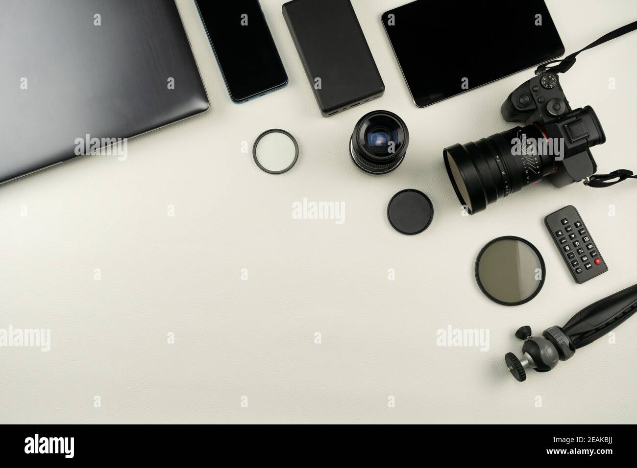 Digital camera with lenses and equipment of the professional photographer on White leather