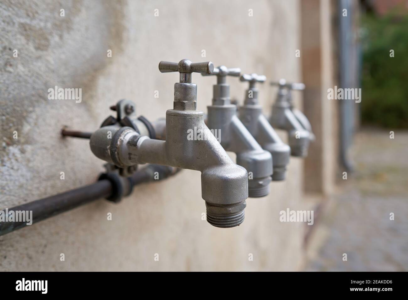 Taps for water supply in the garden on the facade of a house Stock Photo