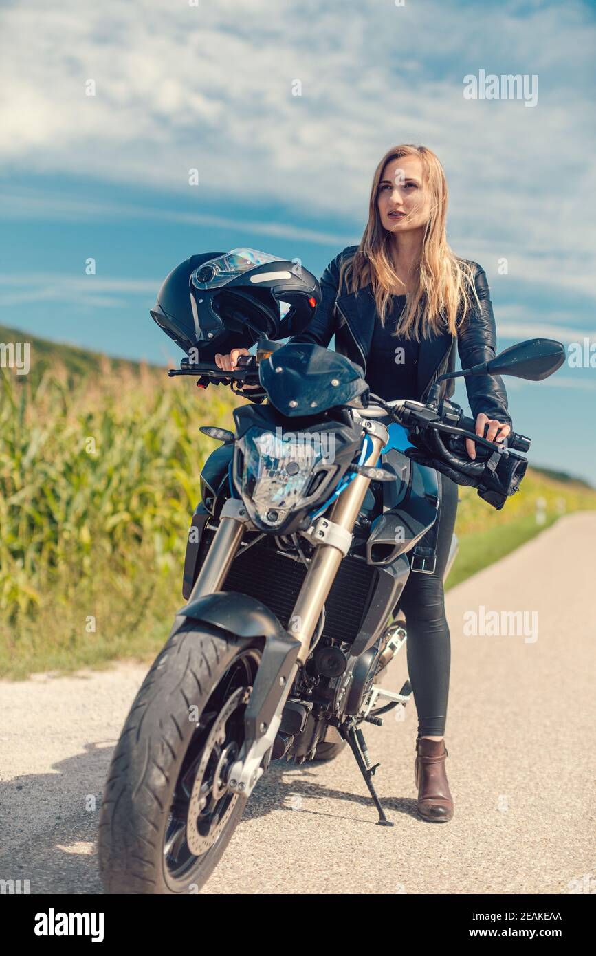 Beautiful woman on a motorcycle looking at the road ahead Stock Photo