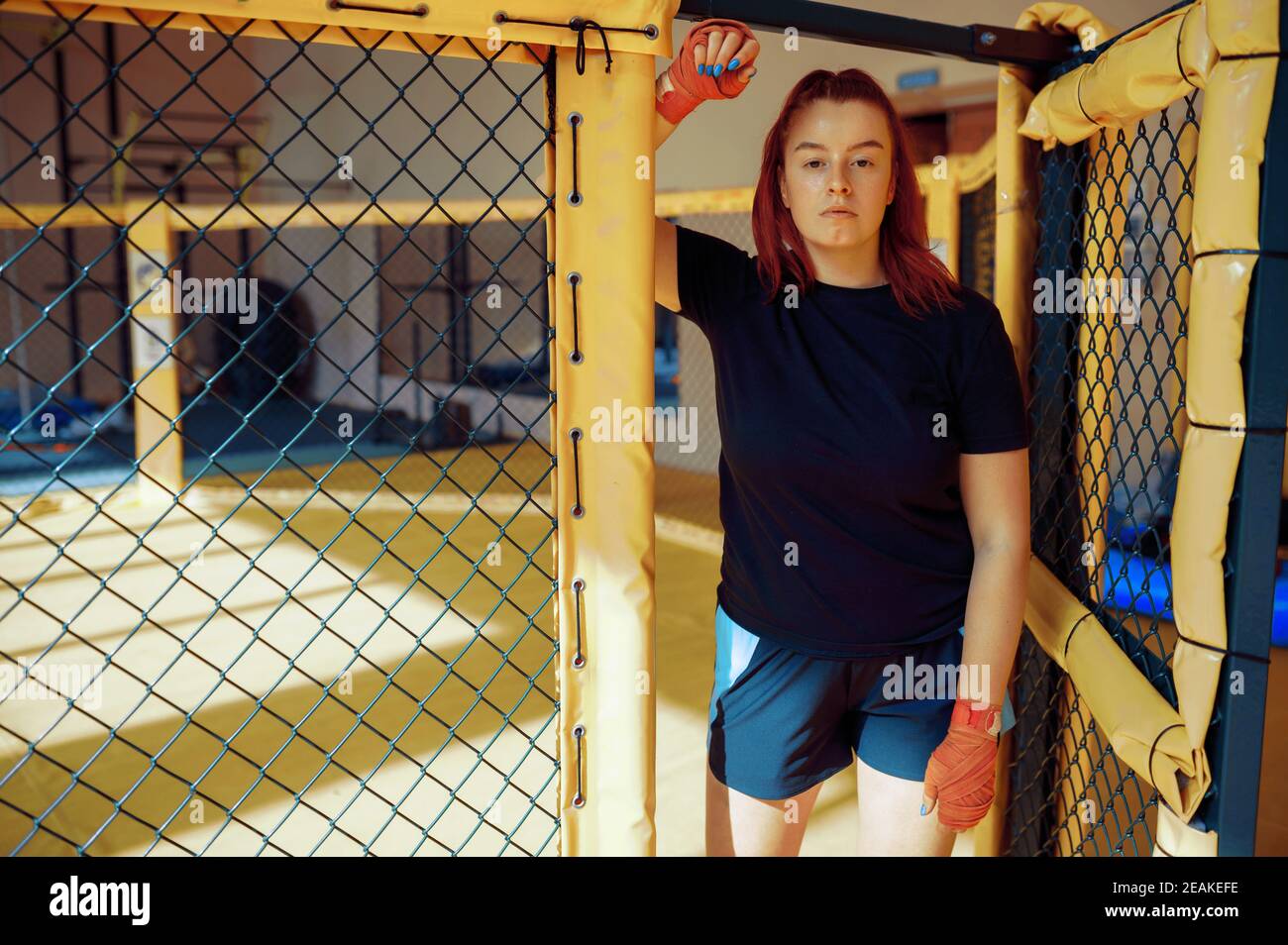 Female MMA fighter in bandages poses in gym Stock Photo