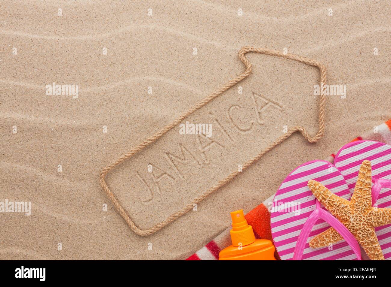 Jamaica  pointer and beach accessories lying on the sand Stock Photo