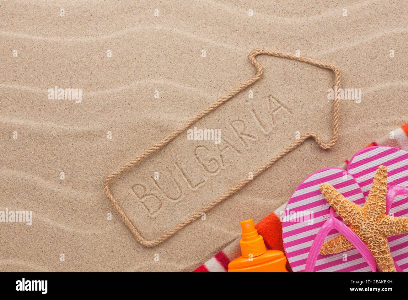 Bulgaria pointer and beach accessories lying on the sand Stock Photo