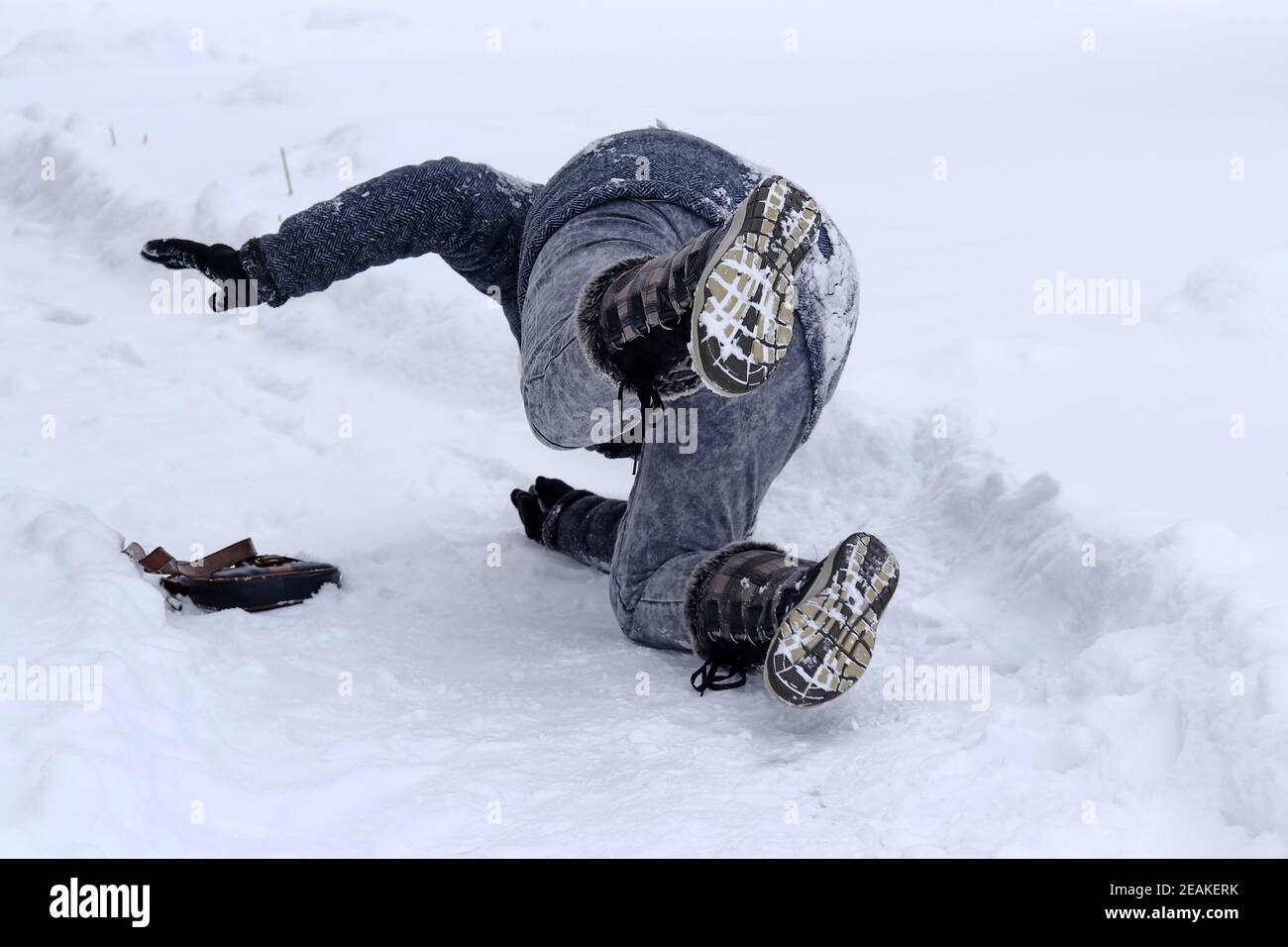 A woman slips on a snowcovered sidewalk Stock Photo Alamy