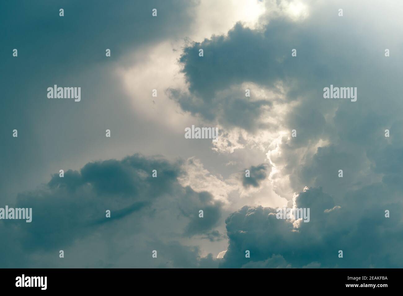Gray sky and fluffy clouds with sunlight. Cloudy sky. Background for death and sad concept. Sad and moody sky. Nature background. Cloudscape. Hope in darkness day. Overcast sky. Sunlight behind clouds Stock Photo