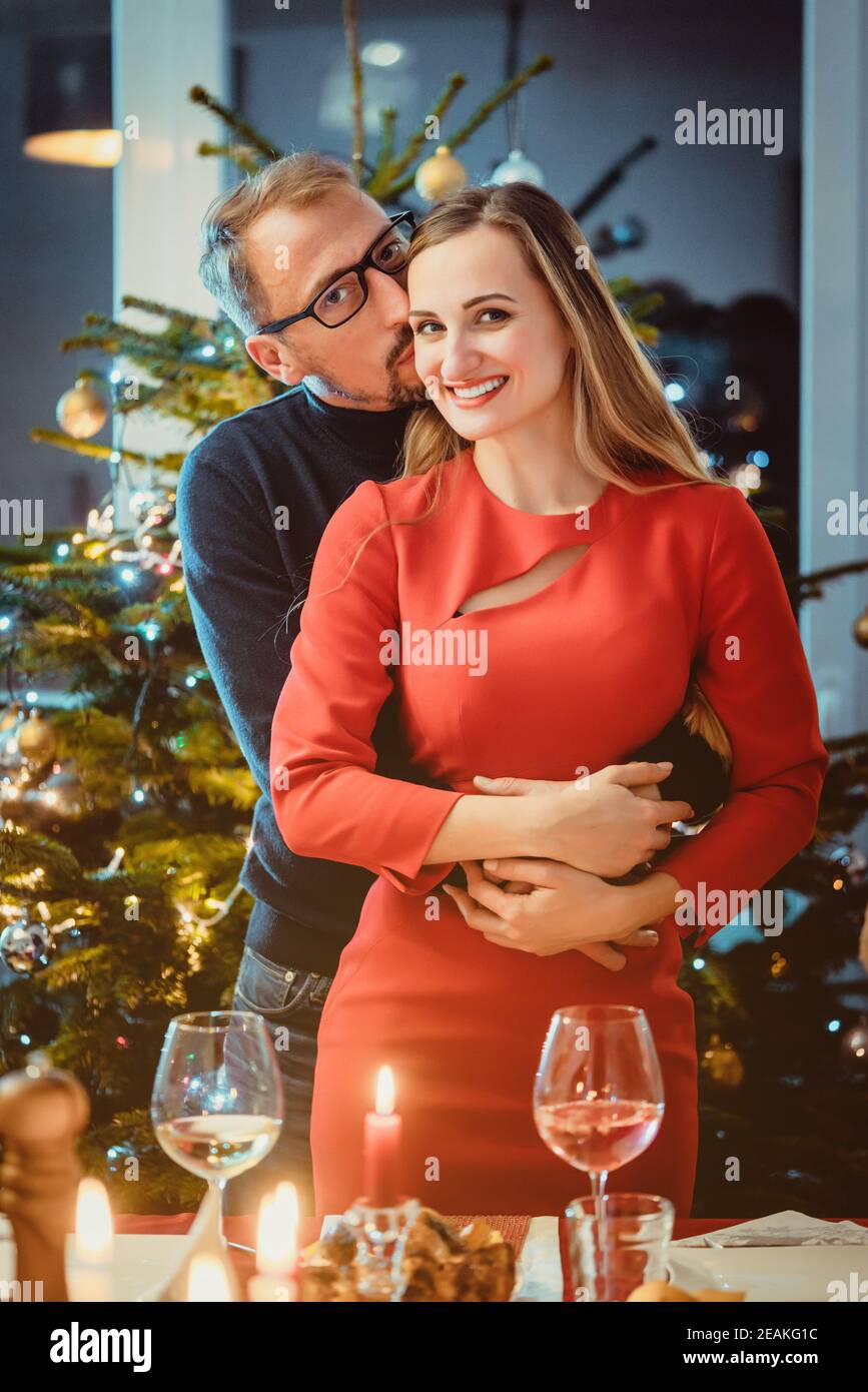Middle aged couple in romantic pose in front of Christmas tree Stock Photo