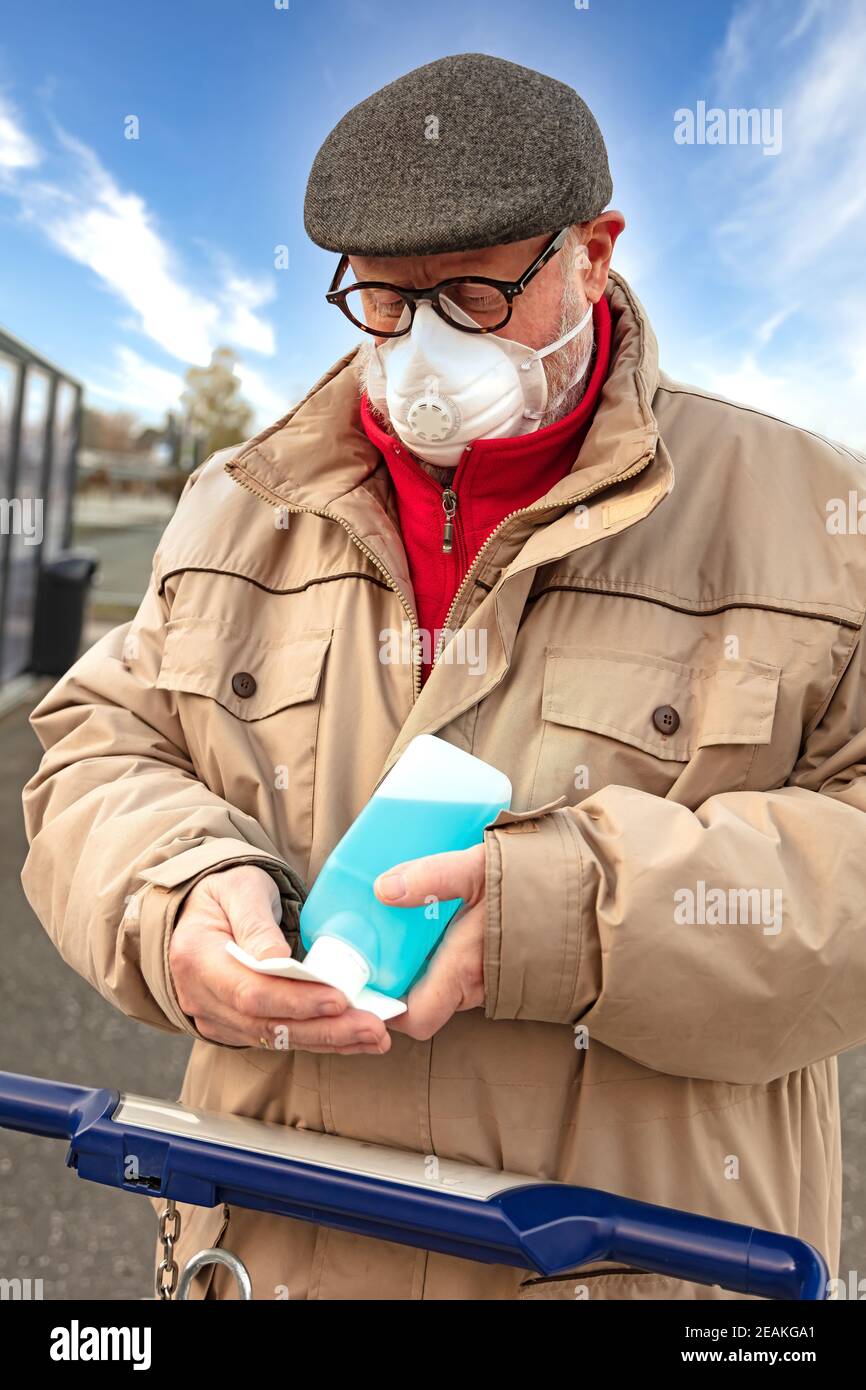 Man disinfected the handle of a shopping trolley Stock Photo