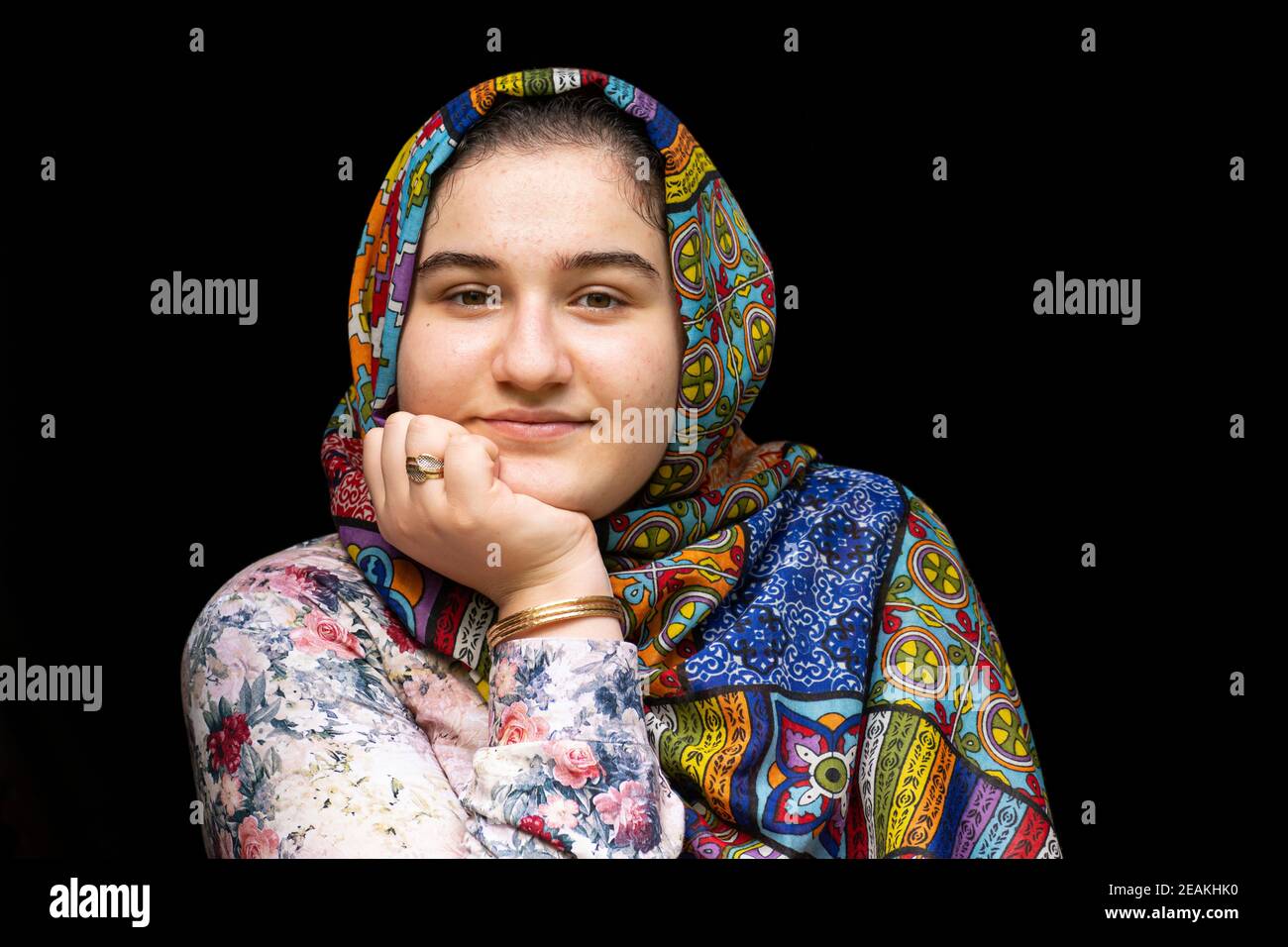 Portrait of a teenage beautiful girl with colorful clothes in front of black background Stock Photo