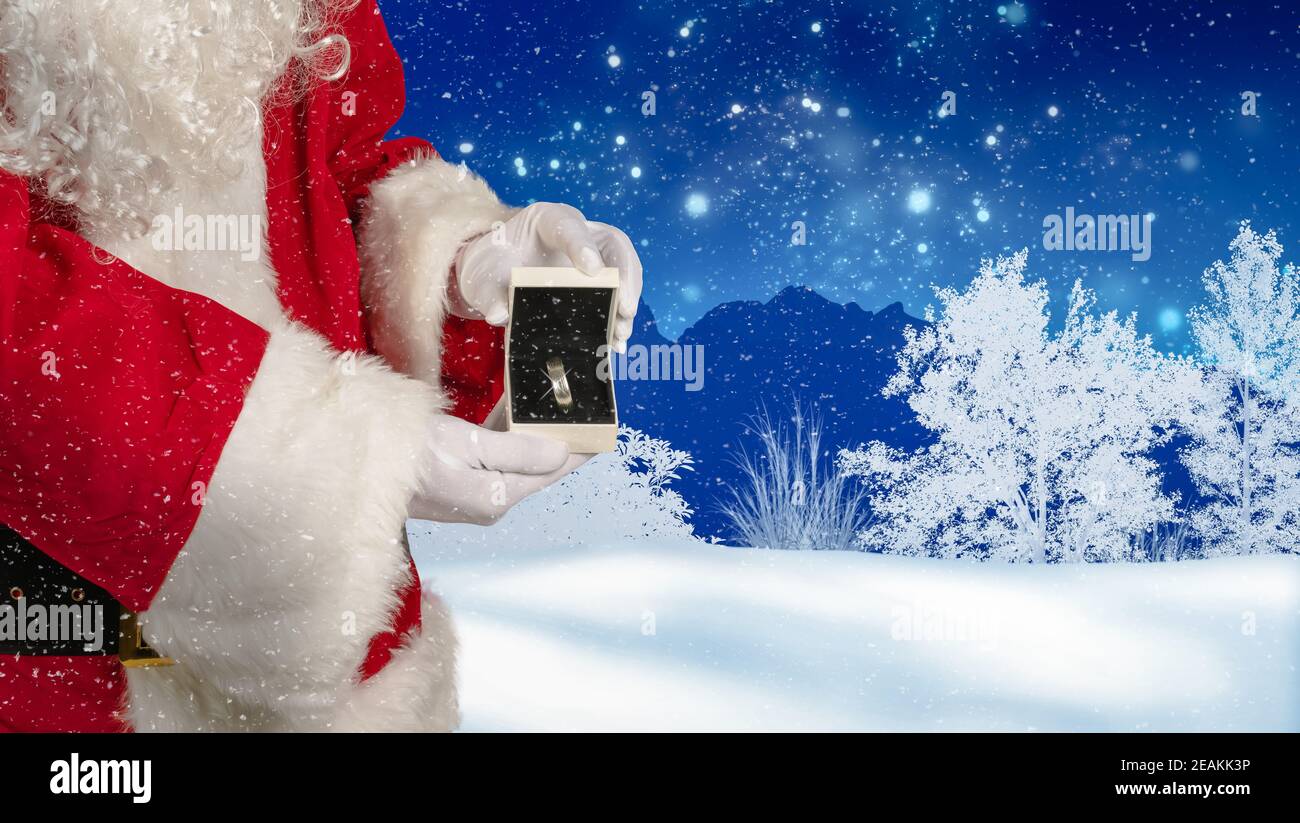 Santa is holding a jewelry case with a ring as a Christmas gift in his hand Stock Photo